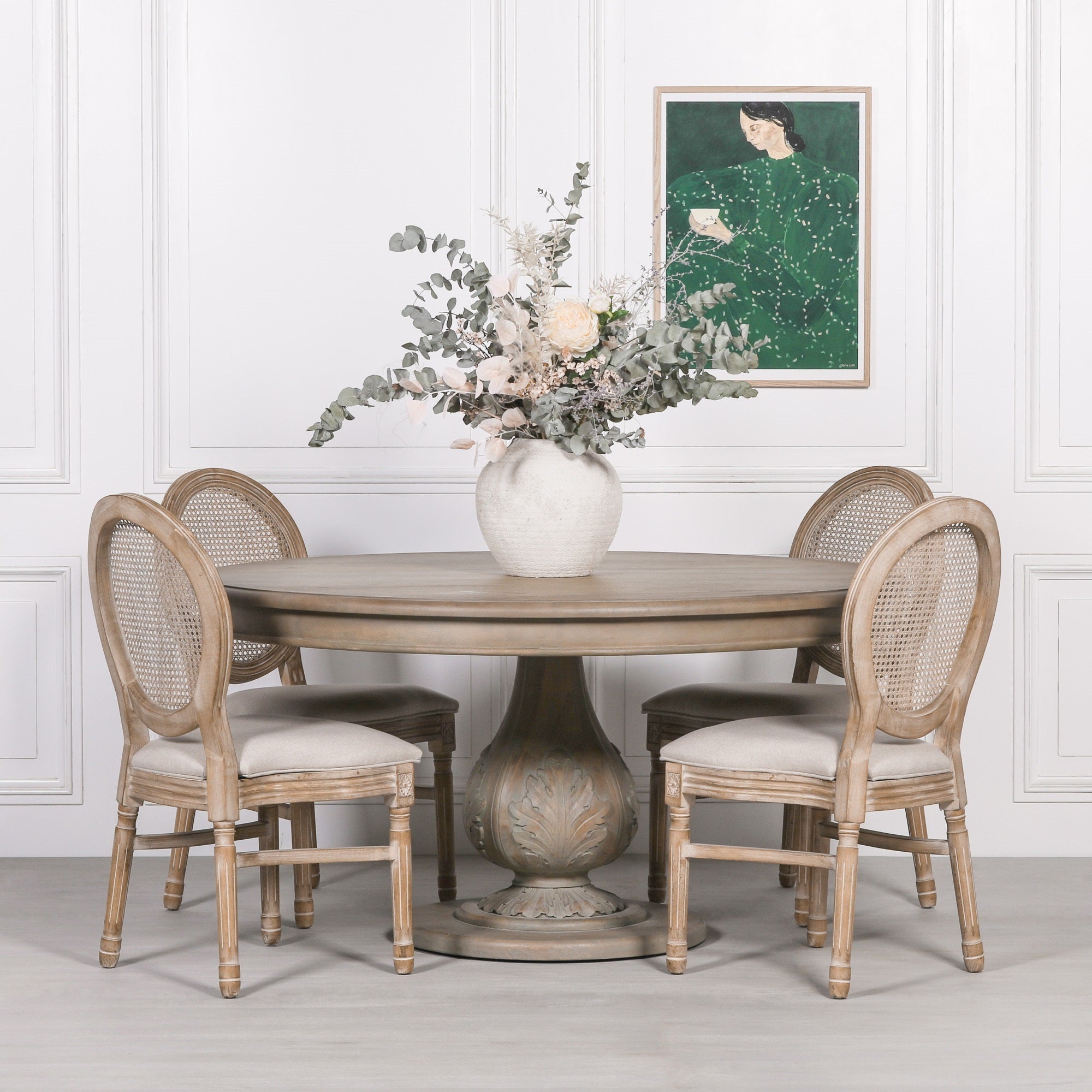Auguste Round Acorn Pedestal Dining Table 150cm for 6 in Rustic Washed Hardwood styled with upholstered rattan dining chairs and a floral centrepiece, showcasing the sculptural carved acorn pedestal base, spacious round tabletop and timeless French country dining room furniture for family dining and entertaining.