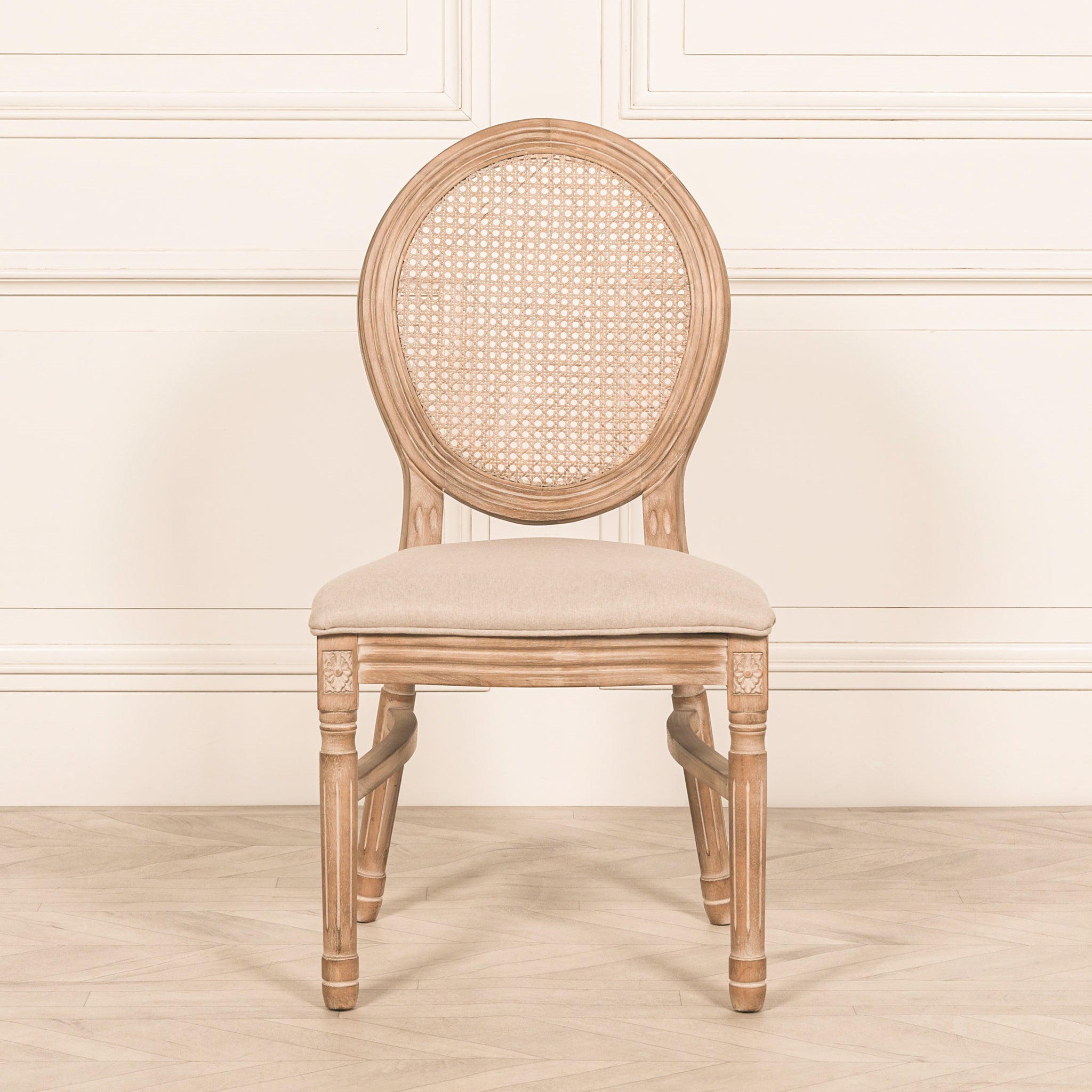 Front view of the Camille French Louis Linen Upholstered Dining Chair featuring a hand-carved natural wooden frame, oval cane backrest, woven rattan detailing and a comfortable linen upholstered seat, ideal for French country and luxury dining rooms.