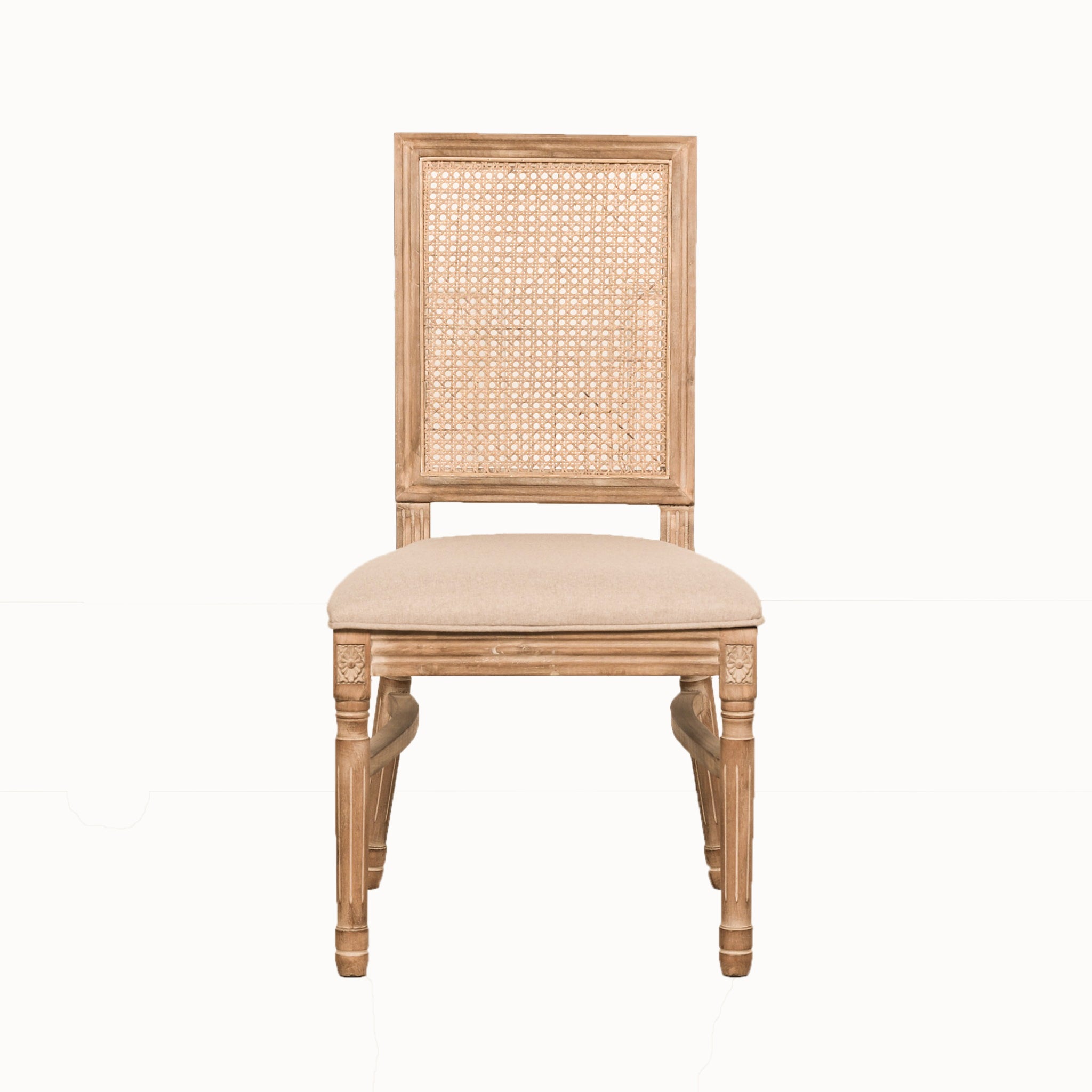 Front view of the Camille French Louis Rattan Back Dining Chair featuring a woven rattan backrest, linen upholstered seat and hand-carved wooden frame on a white background.