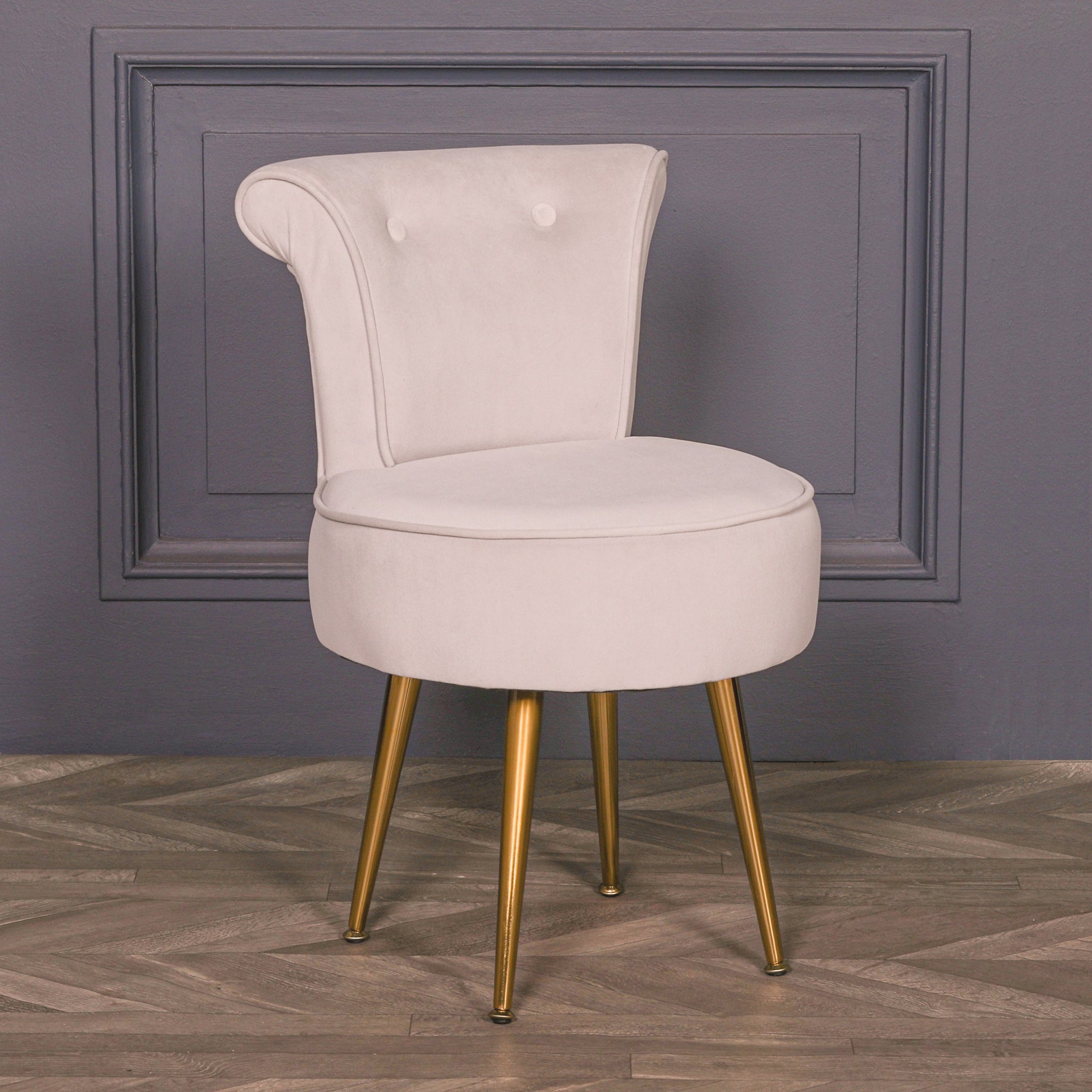 Lucien Light Grey Velvet Accent Bedroom Chair with Gold-Plated Legs styled in a contemporary interior, featuring soft light grey velvet upholstery, sculpted wraparound backrest, button detailing and elegant tapered gold-plated legs.