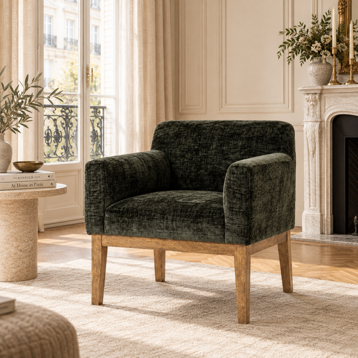 Maël dark green upholstered dining armchair with natural wood legs in a Parisian room with fireplace and cream rug.