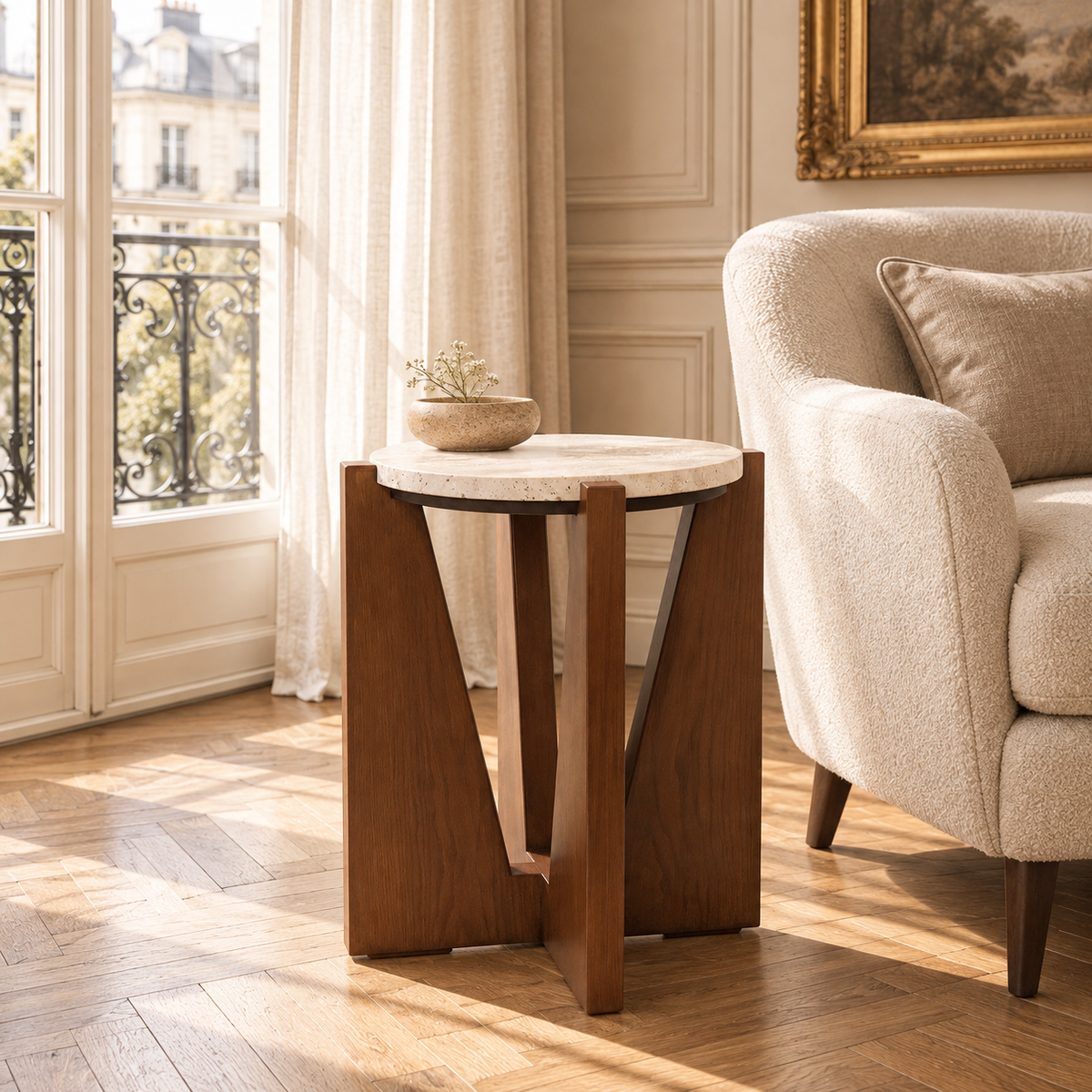 Soline travertine side table with acacia wood frame beside a cream chair in a sunlit Parisian-style living room.