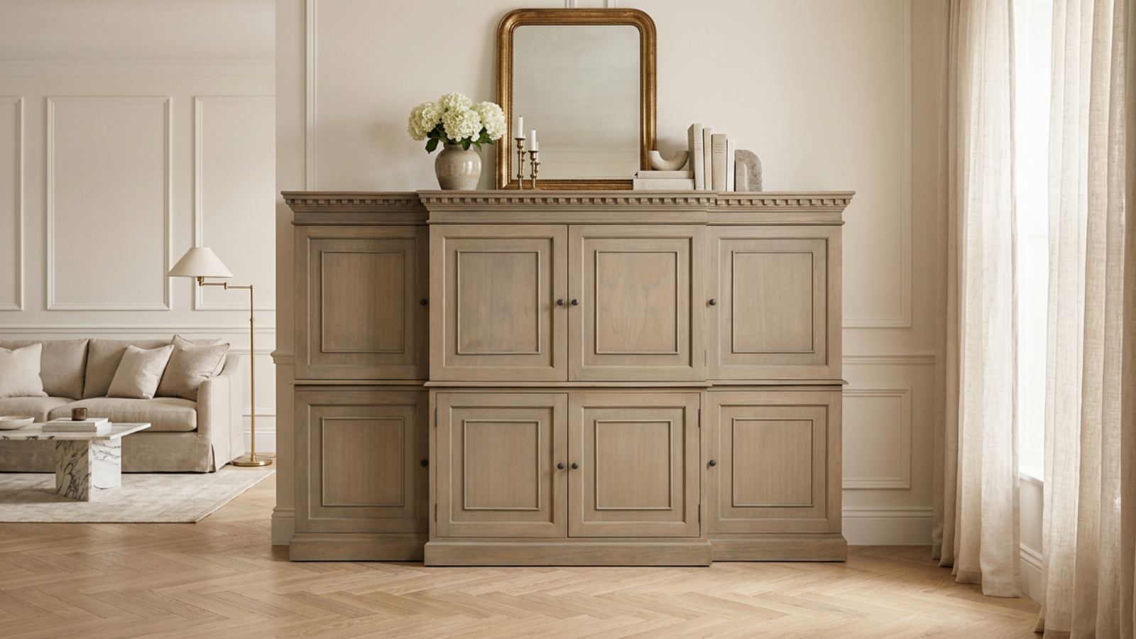 Hidden TV cabinet styled in a Parisian-inspired living room beneath a gold wall mirror with elegant concealed storage, neutral décor and timeless luxury interior design.
