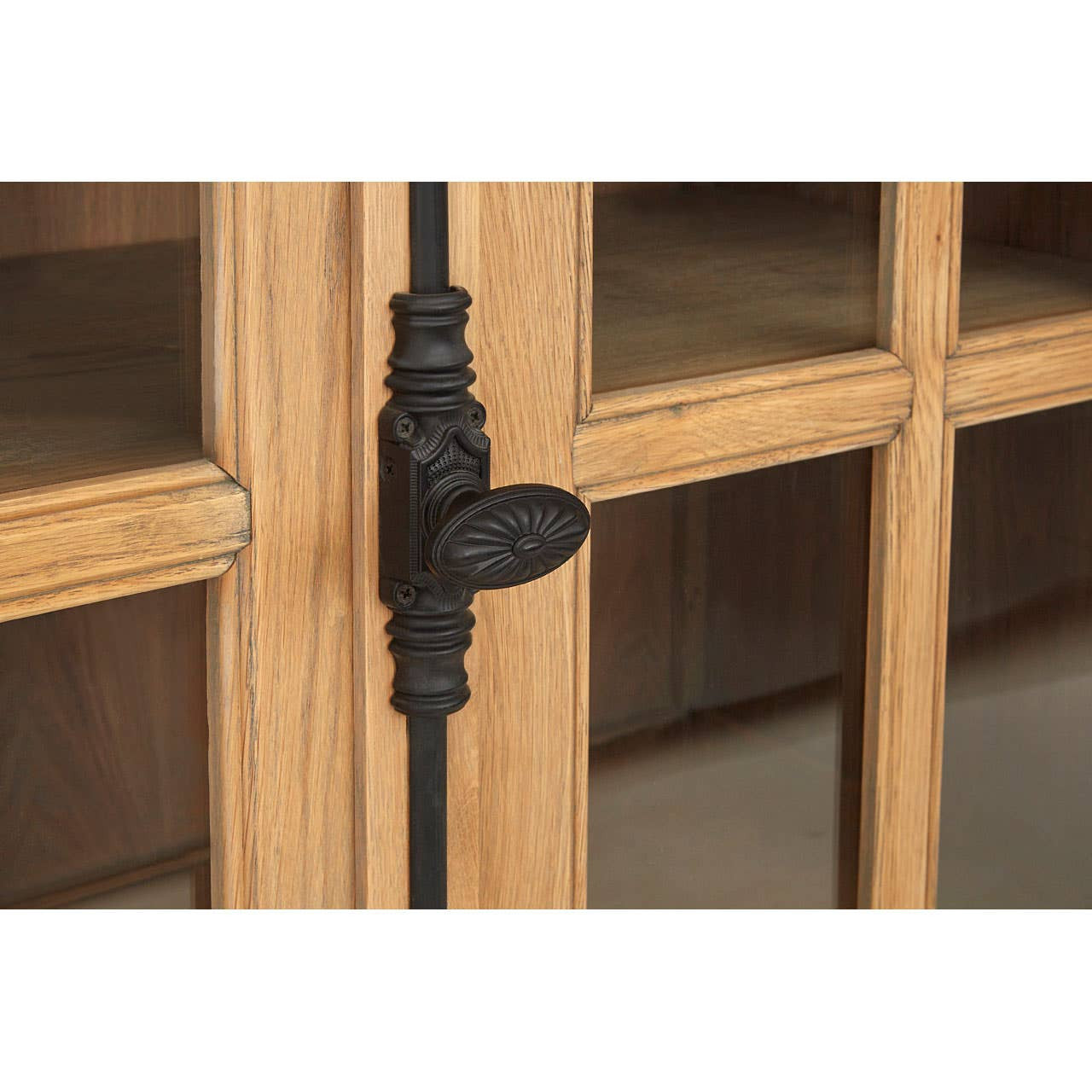 Close-up of the Alaric Four Door Display Sideboard featuring decorative black metal door handle hardware, glazed oak cabinet doors, washed oak wood grain and premium handcrafted detailing.