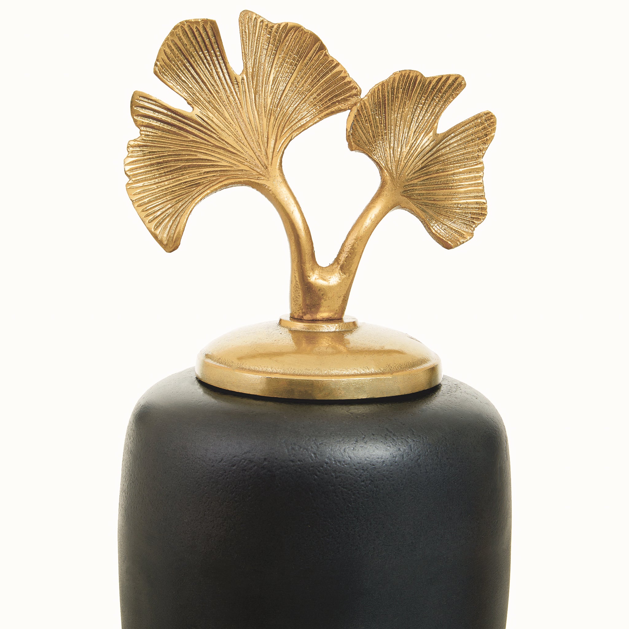 Detailed view of the Alix grey aluminium decorative ginger jar showing the sculptural gold ginkgo leaf finial with finely textured botanical leaves above the rounded dark grey body.
