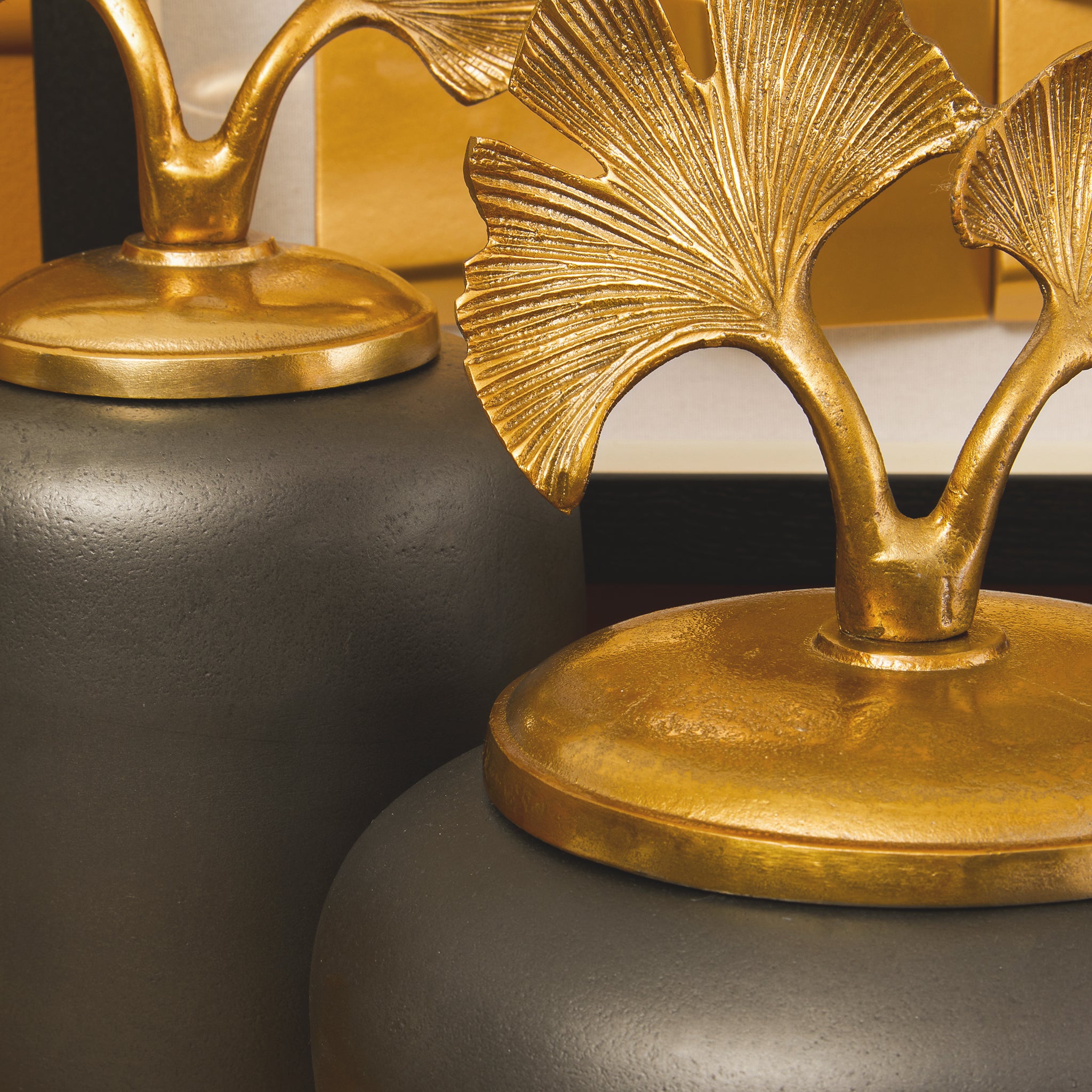 Close-up of the Alix decorative ginger jar highlighting the textured gold ginkgo leaf lid, sculptural botanical detailing and contrasting dark grey aluminium body.