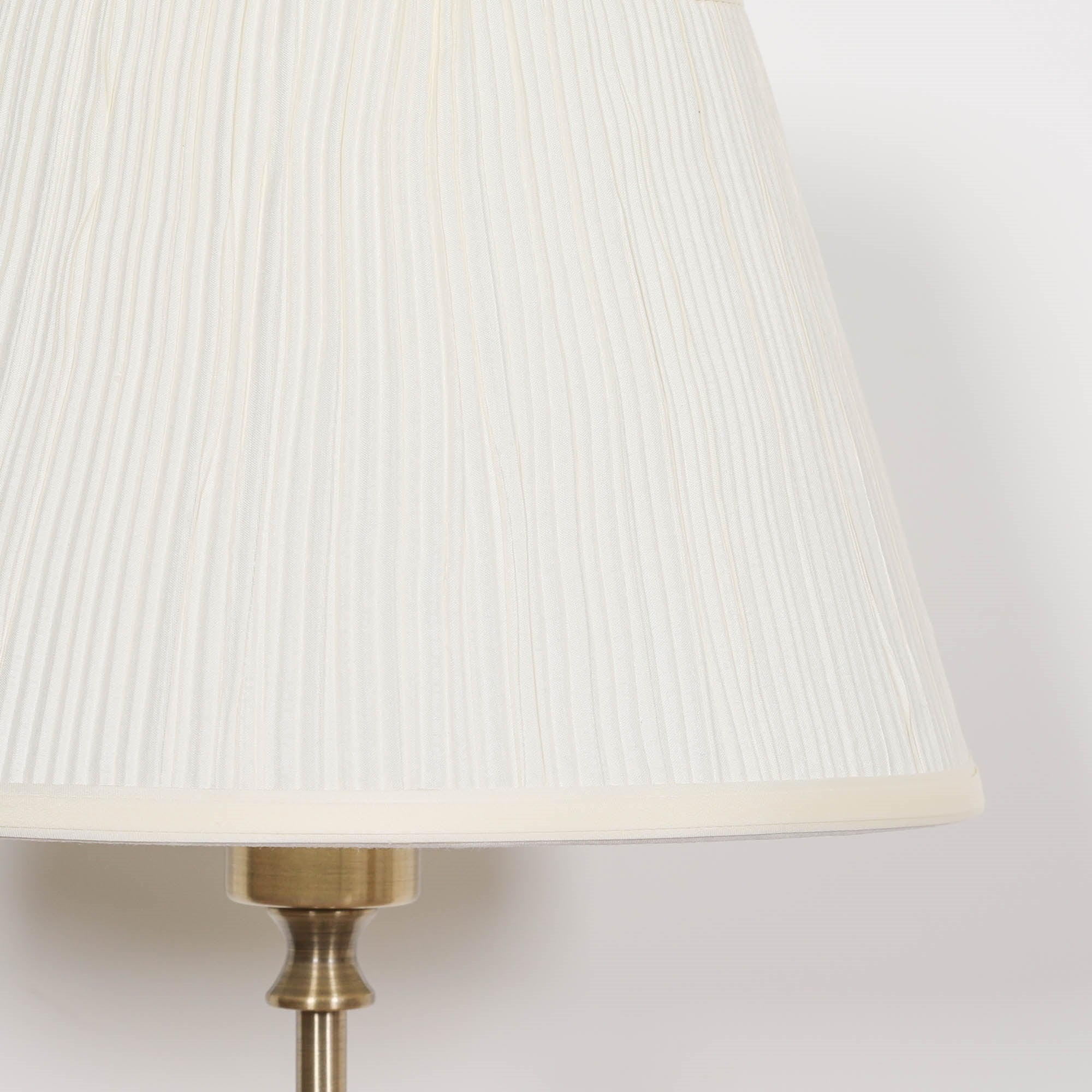 Detailed close-up of the cream pleated fabric lampshade on the Amélie Classical satin brass candlestick table lamp highlighting the elegant textured shade and timeless traditional design.