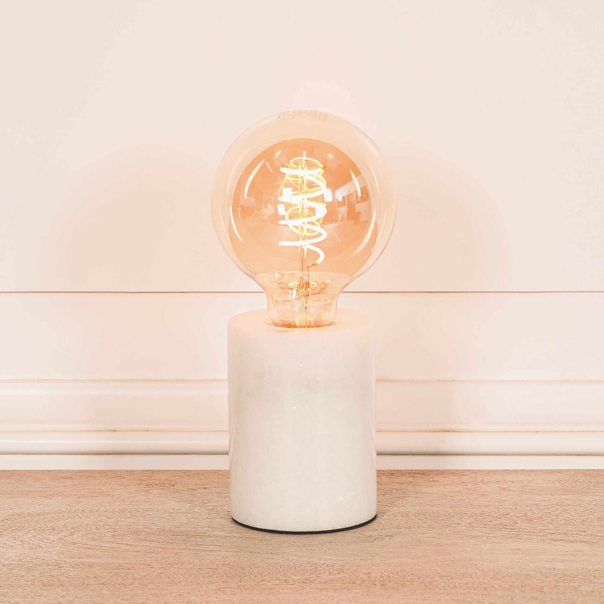Amélie Industrial White Marble Table Lamp with Braided Cord against a neutral background highlighting the premium natural white marble base, exposed spiral Edison bulb and minimalist industrial table lamp design.