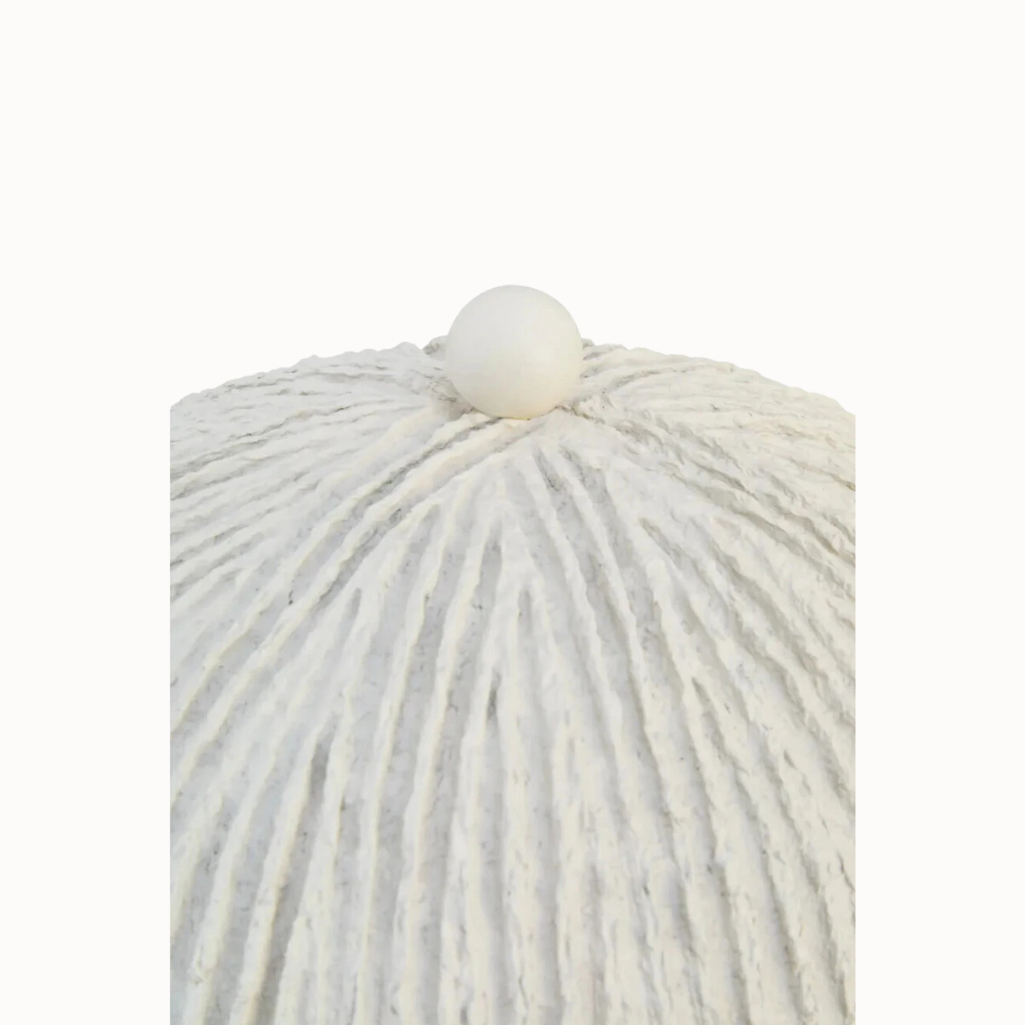 Close-up of ribbed oatmeal papier mâché dome and round finial on a plain white background.