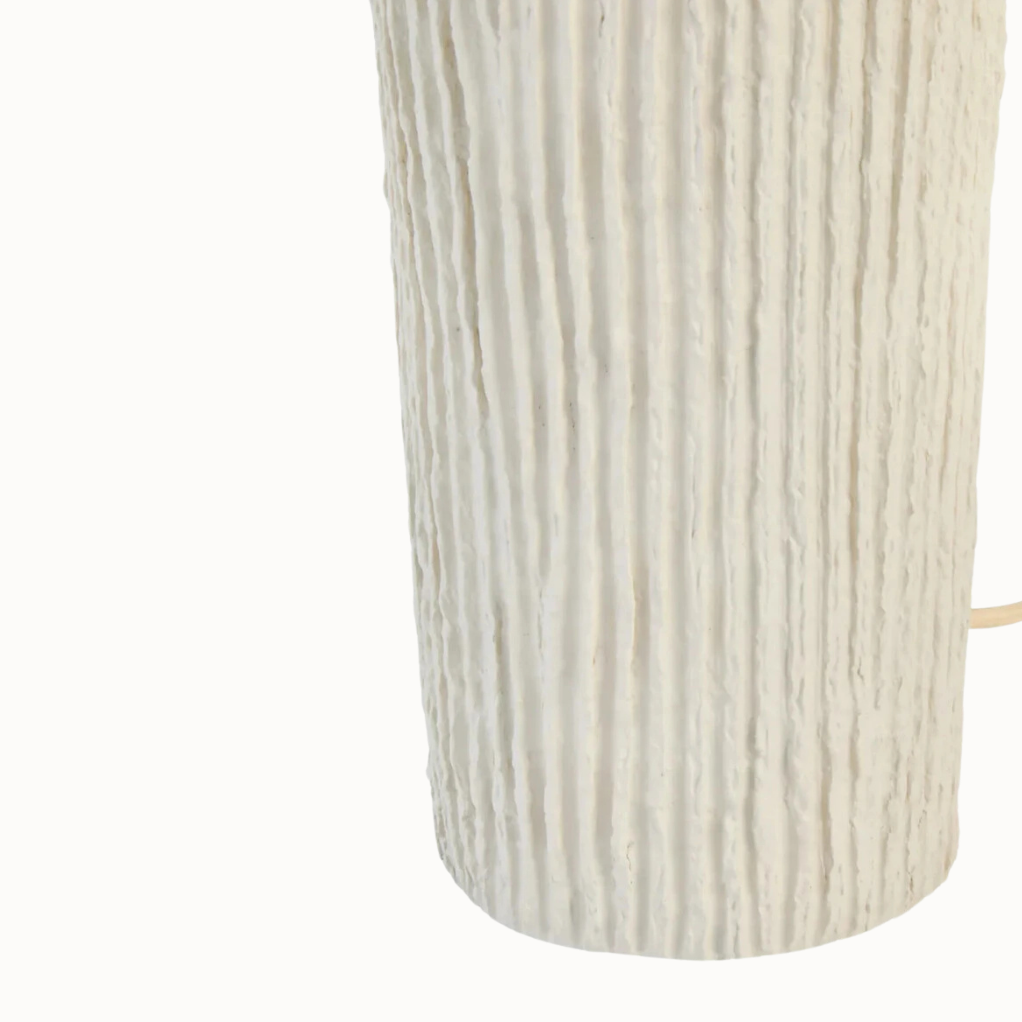 Close-up of etched linear papier mâché lamp base on a plain white background.