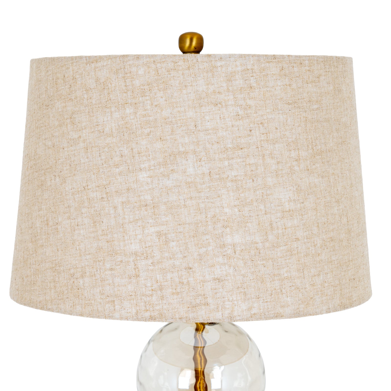 Close-up of Amélie table lamp linen shade with gold finial and clear glass base on a white background.