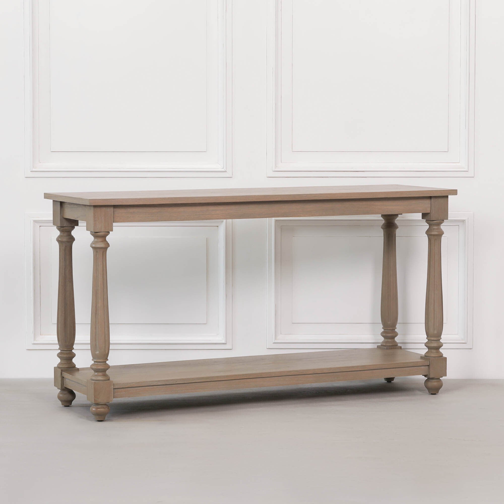 Angled view of Armand large white cedar console table with traditional turned legs and practical lower shelf