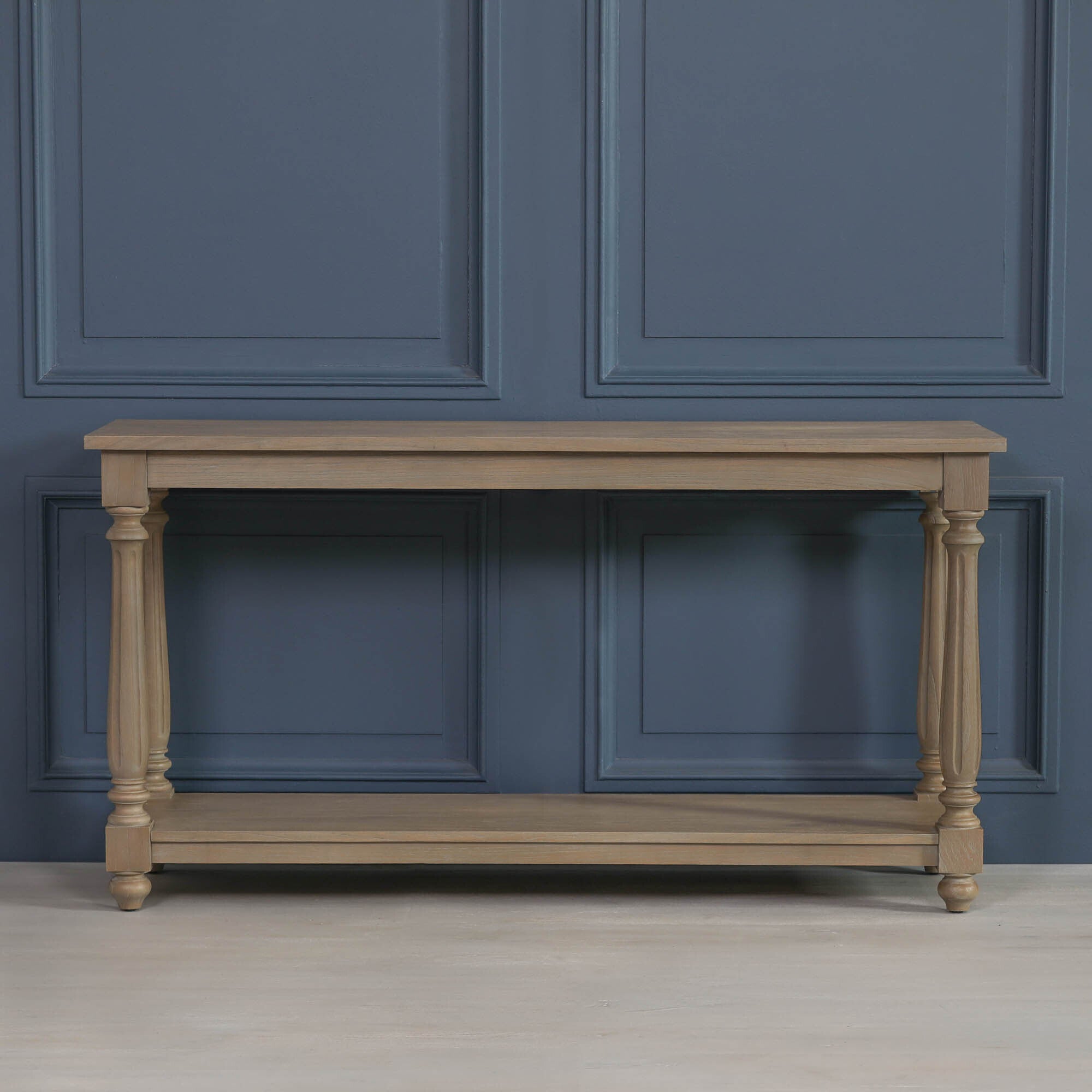 Armand large white cedar console table with turned legs and lower storage shelf against a blue panelled wall