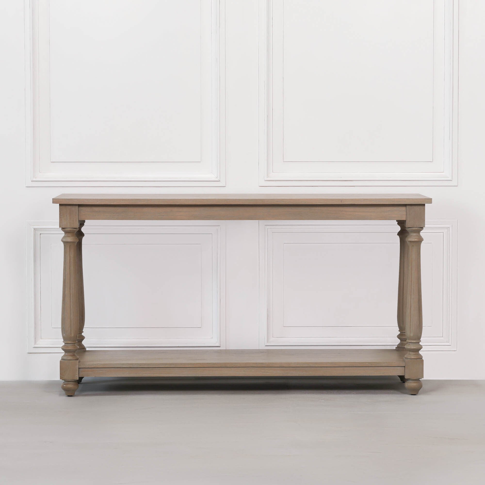 Front view of Armand large white cedar console table with turned legs and full-width lower storage shelf