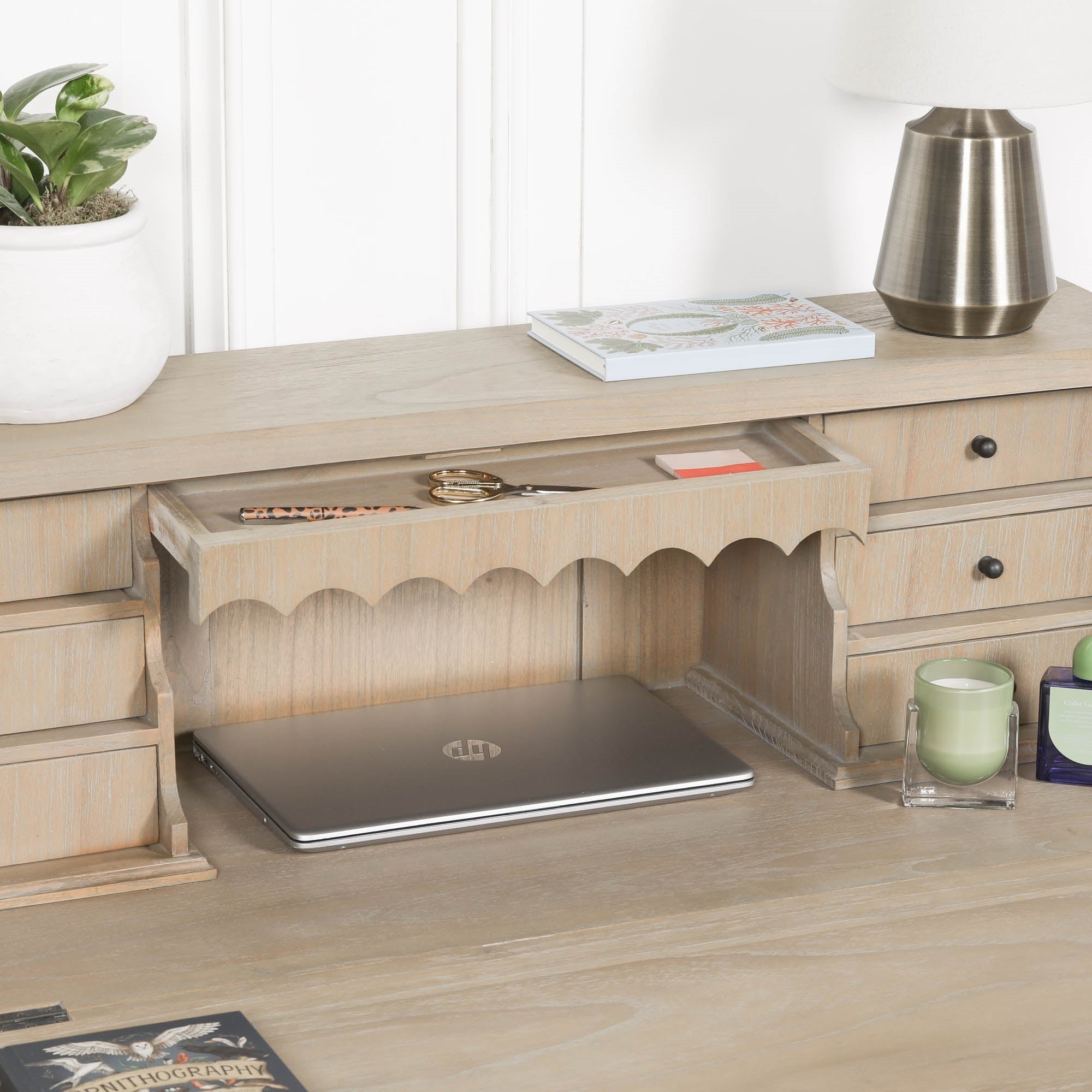 Armand white cedar bureau desk close-up with open centre drawer, laptop and accessories against a white wall.