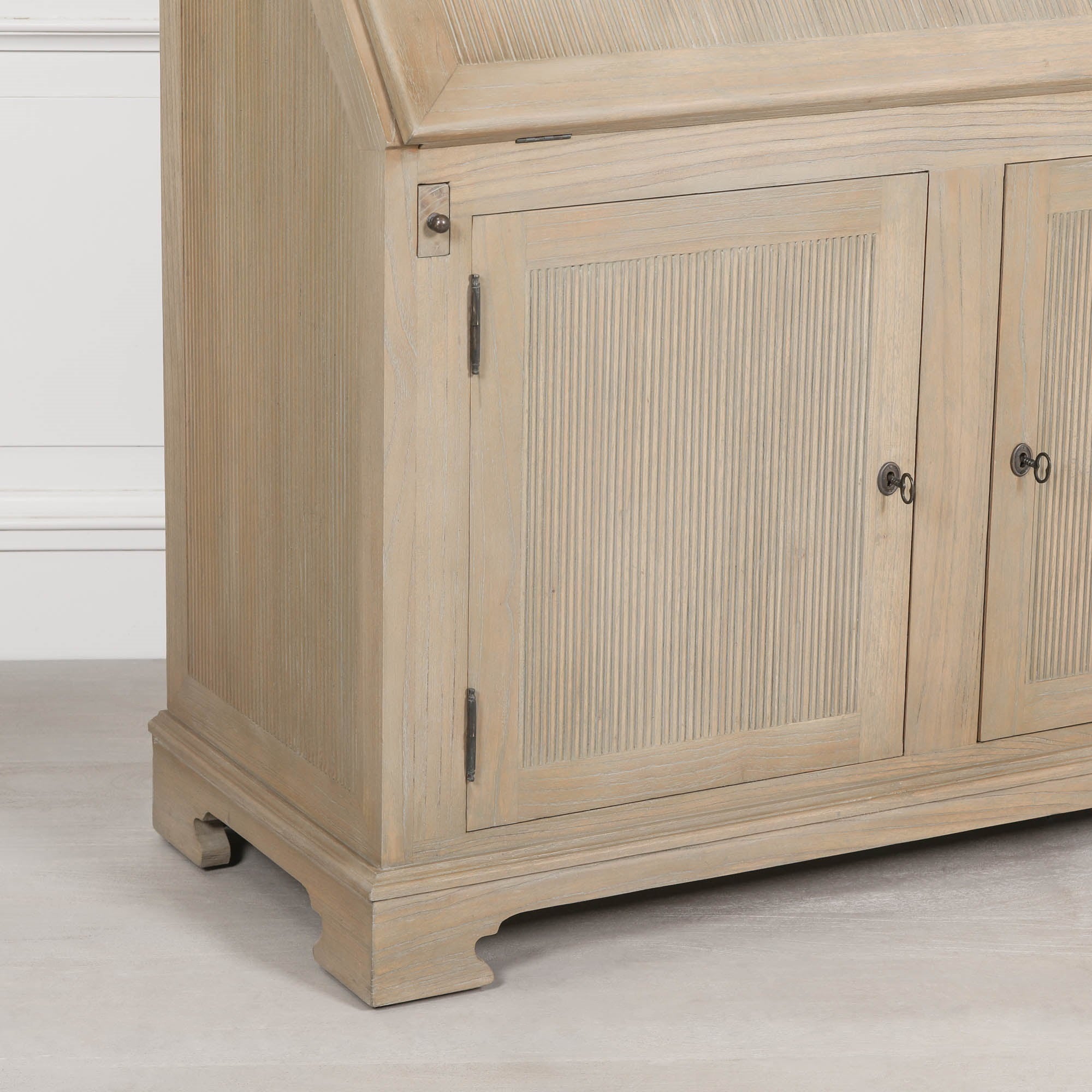 Armand white cedar bureau desk close-up showing reeded storage doors and antique-style hardware on a white backdrop.