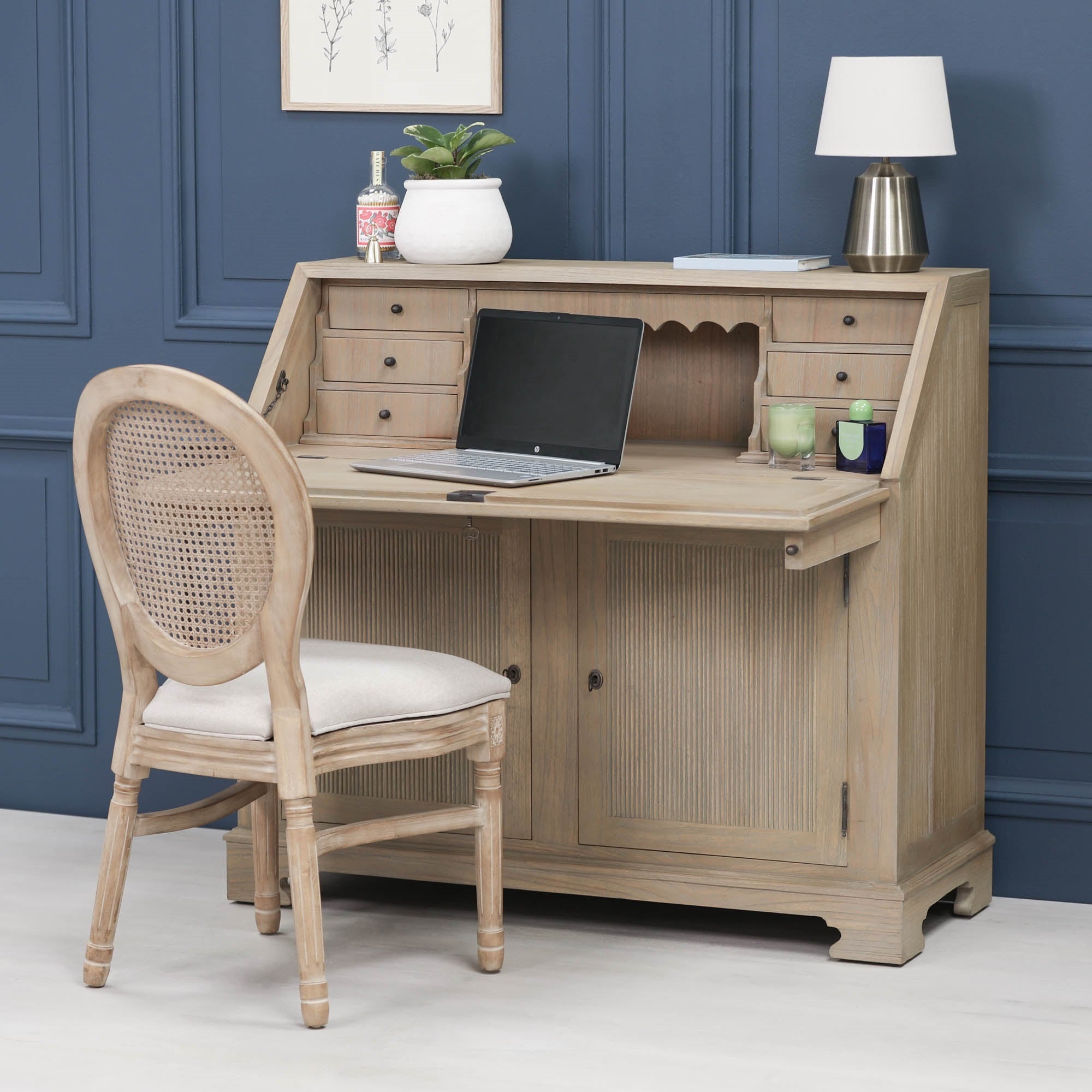 Armand white cedar bureau writing desk with chair and laptop against a dark blue panelled wall.