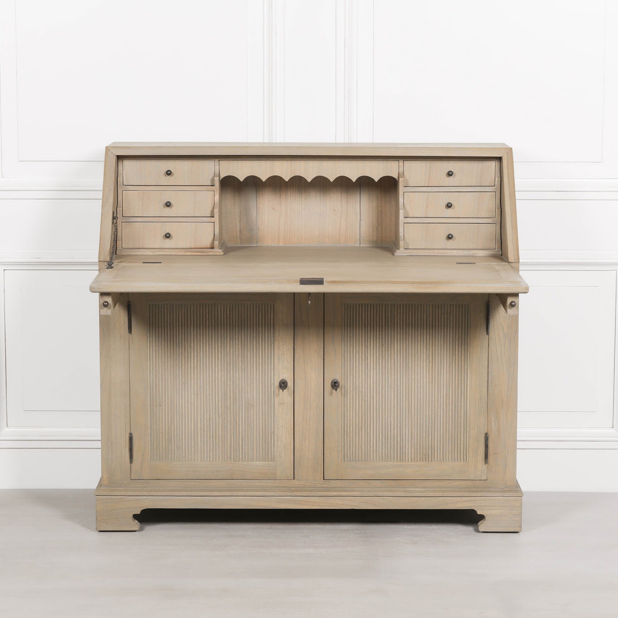 Armand white cedar bureau writing desk open with drawers and storage doors against a white panelled wall.