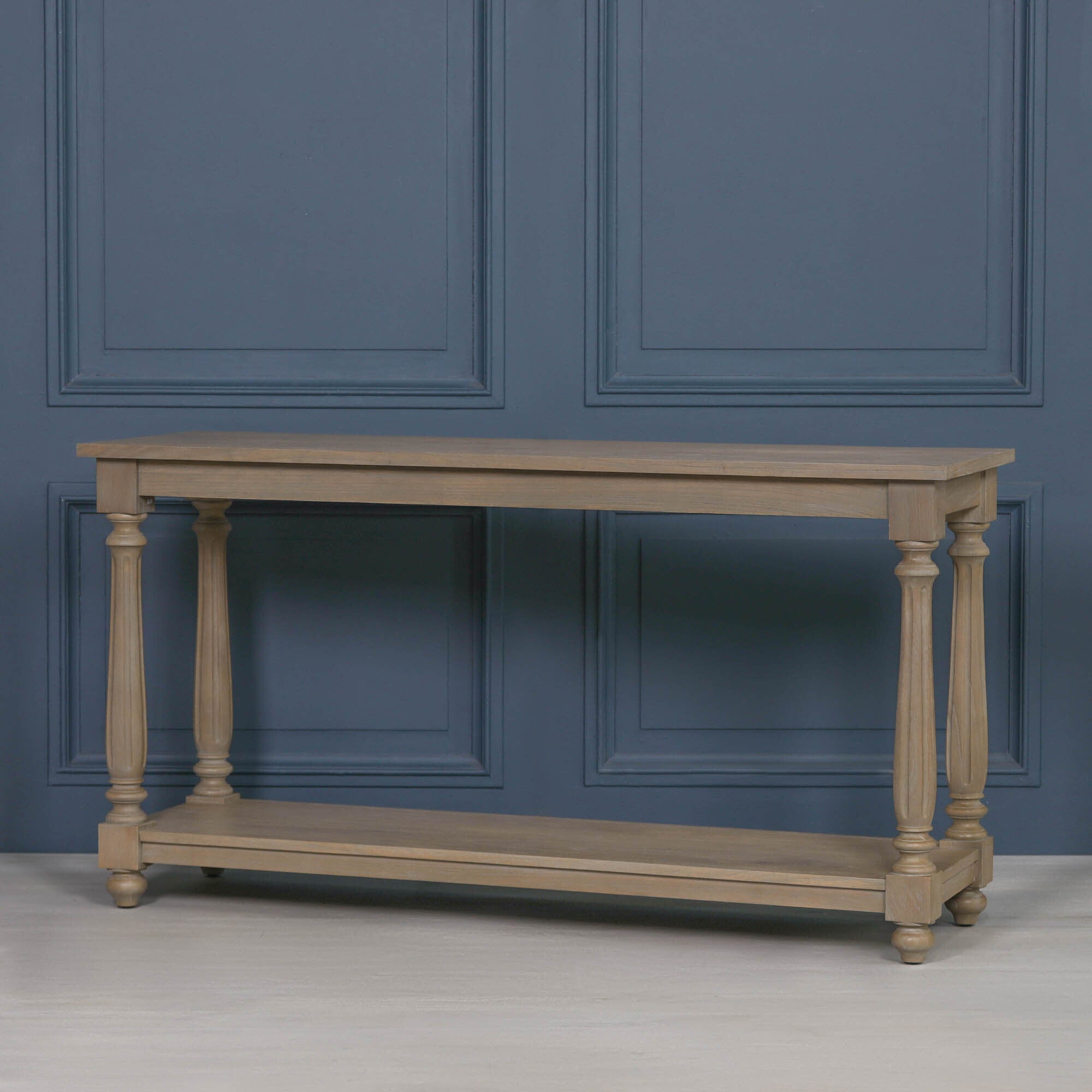 Armand white cedar wood console table with turned legs and lower shelf shown from an angled view