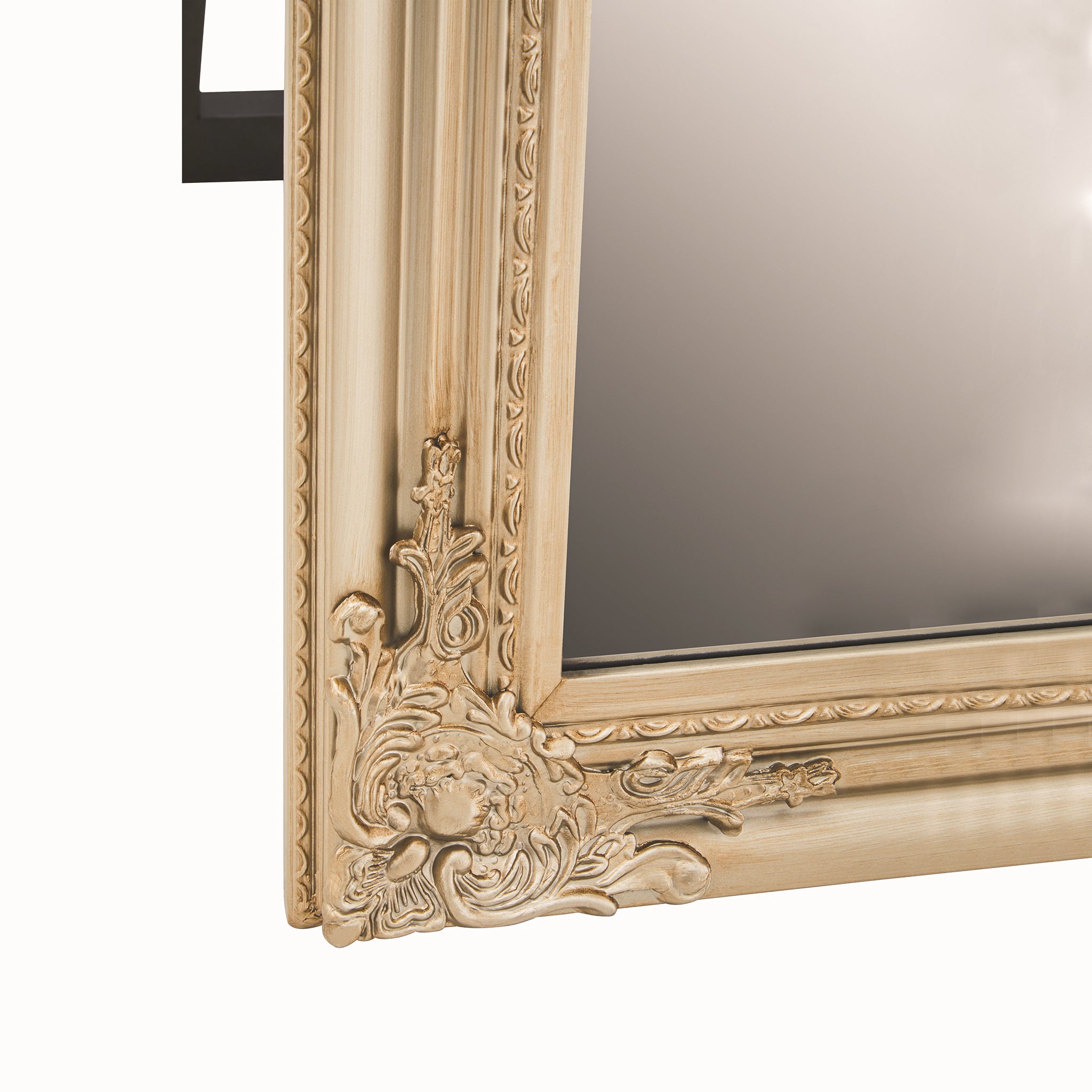 Close-up of the Aurelia rectangular champagne gilded floor mirror showing ornate floral corner embellishment, decorative moulded frame detailing and the edge of the full-length mirrored glass.
