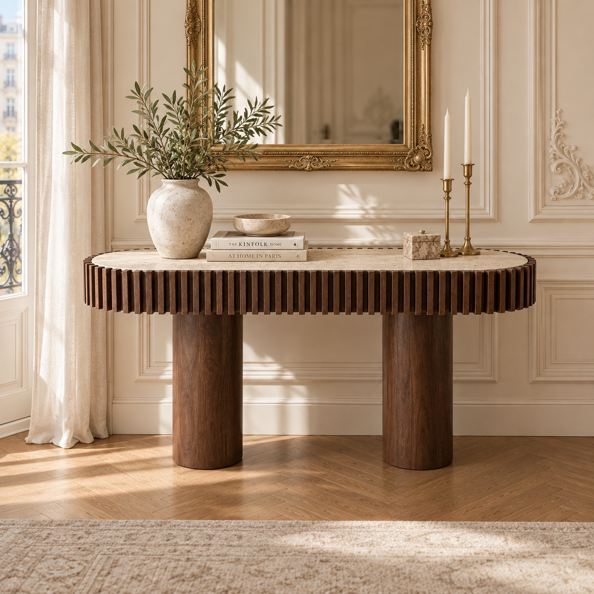 120cm travertine top mango wood fluted console table in a Parisian interior with gold mirror, vase and cream walls.