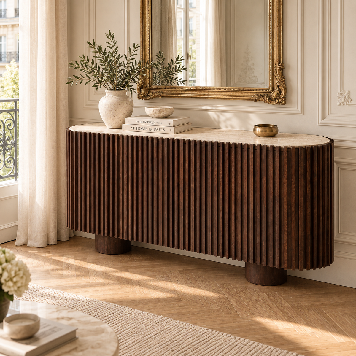 160cm travertine top mango wood fluted sideboard in a Parisian interior with gold mirror, books and cream walls.