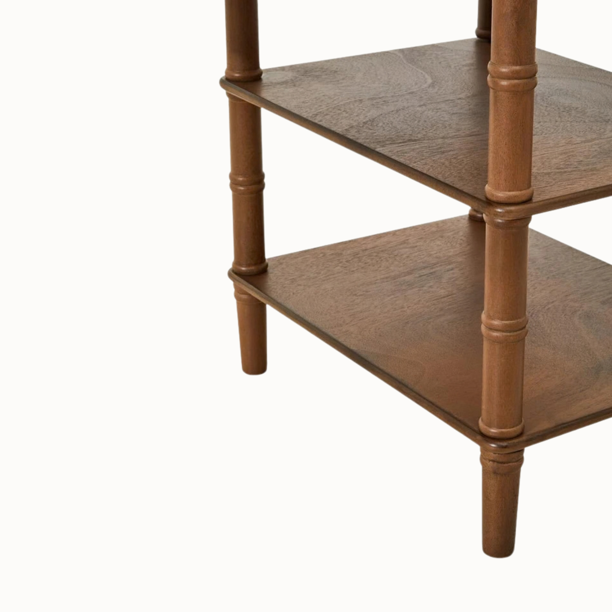 Aveline brown wood writing desk in three-quarter view, featuring one drawer, two open shelves and turned legs on white.
