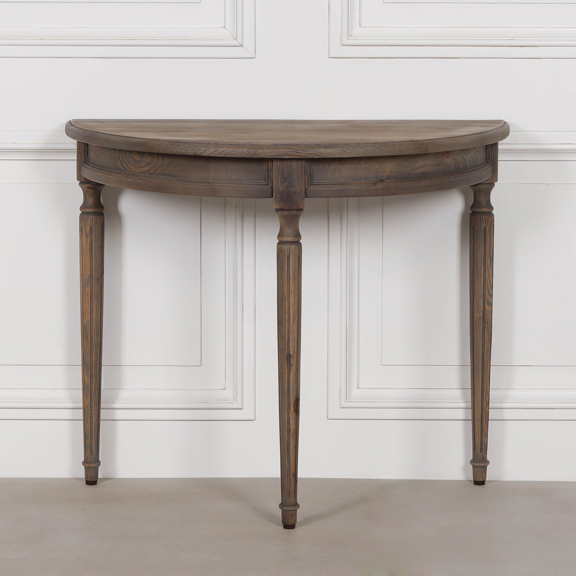 Aveline rustic pine demi-lune console table front view, showing its curved wooden top, shaped apron and turned legs.