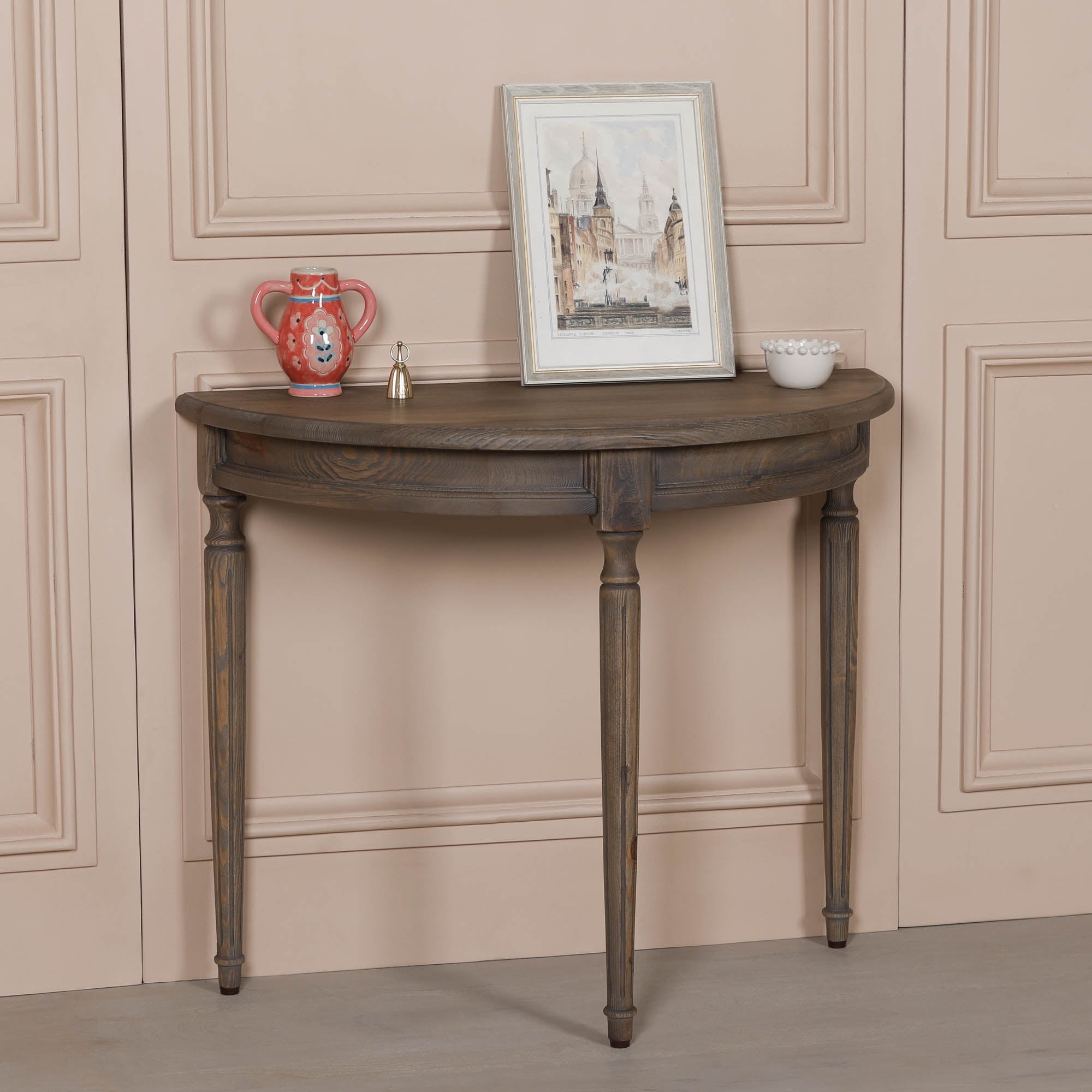Aveline rustic pine demi-lune console table with curved wooden top and turned legs, styled with decorative accessories.