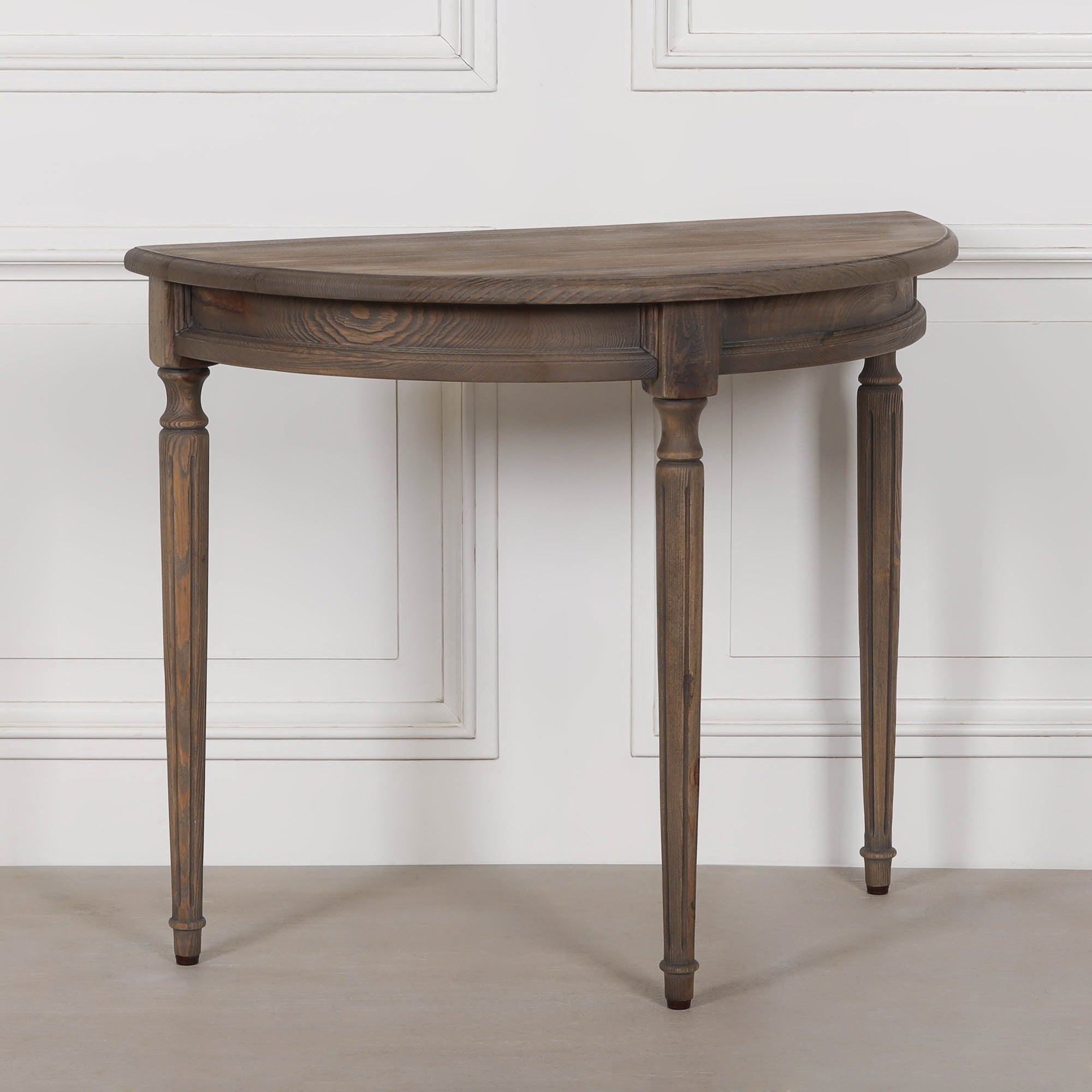 Aveline rustic pine wood demi-lune console table angled view, showing its curved profile, wood grain and turned legs.
