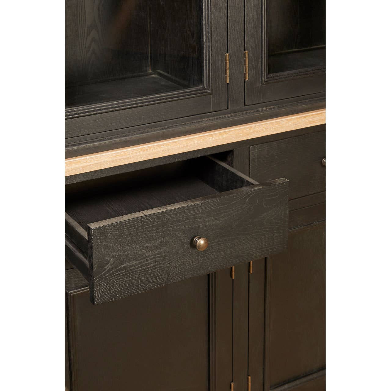 Close-up of the Bastien Four Door Display Cabinet with Drawers in Black Oak Wood featuring an open drawer that highlights the spacious drawer interior, smooth storage functionality and durable black oak wood construction.