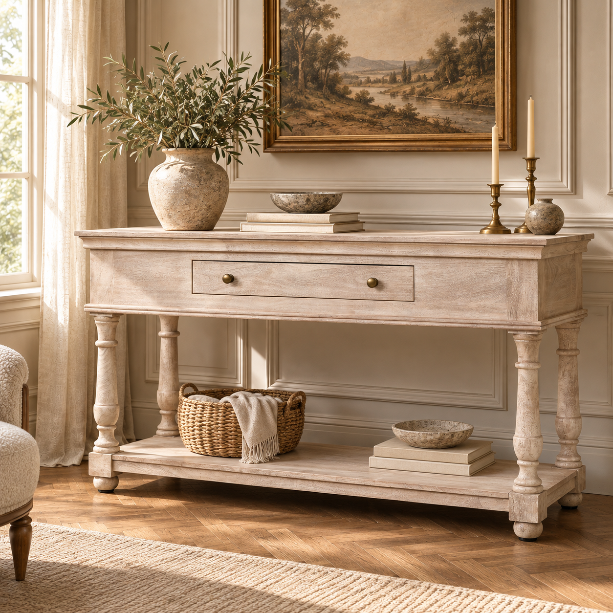 Camille acacia wood console table with drawer and lower shelf behind a cream sofa in a warm French living room