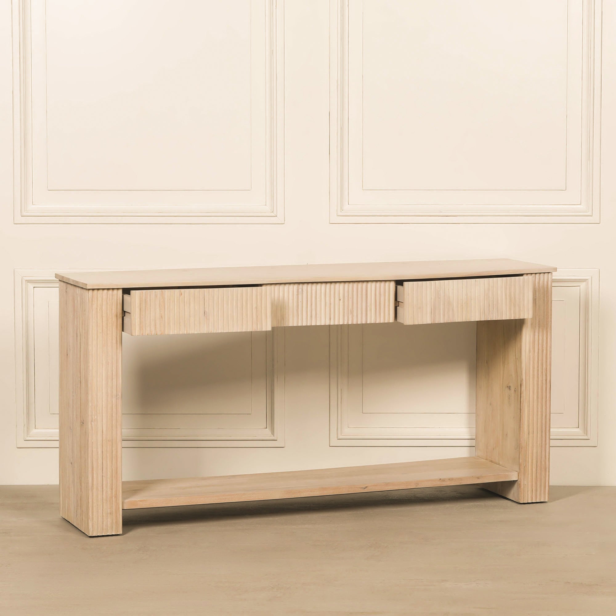 Camille acacia wood console table with all three drawers partially open, highlighting the fluted drawer fronts, spacious tabletop, sturdy legs and full-width lower shelf.