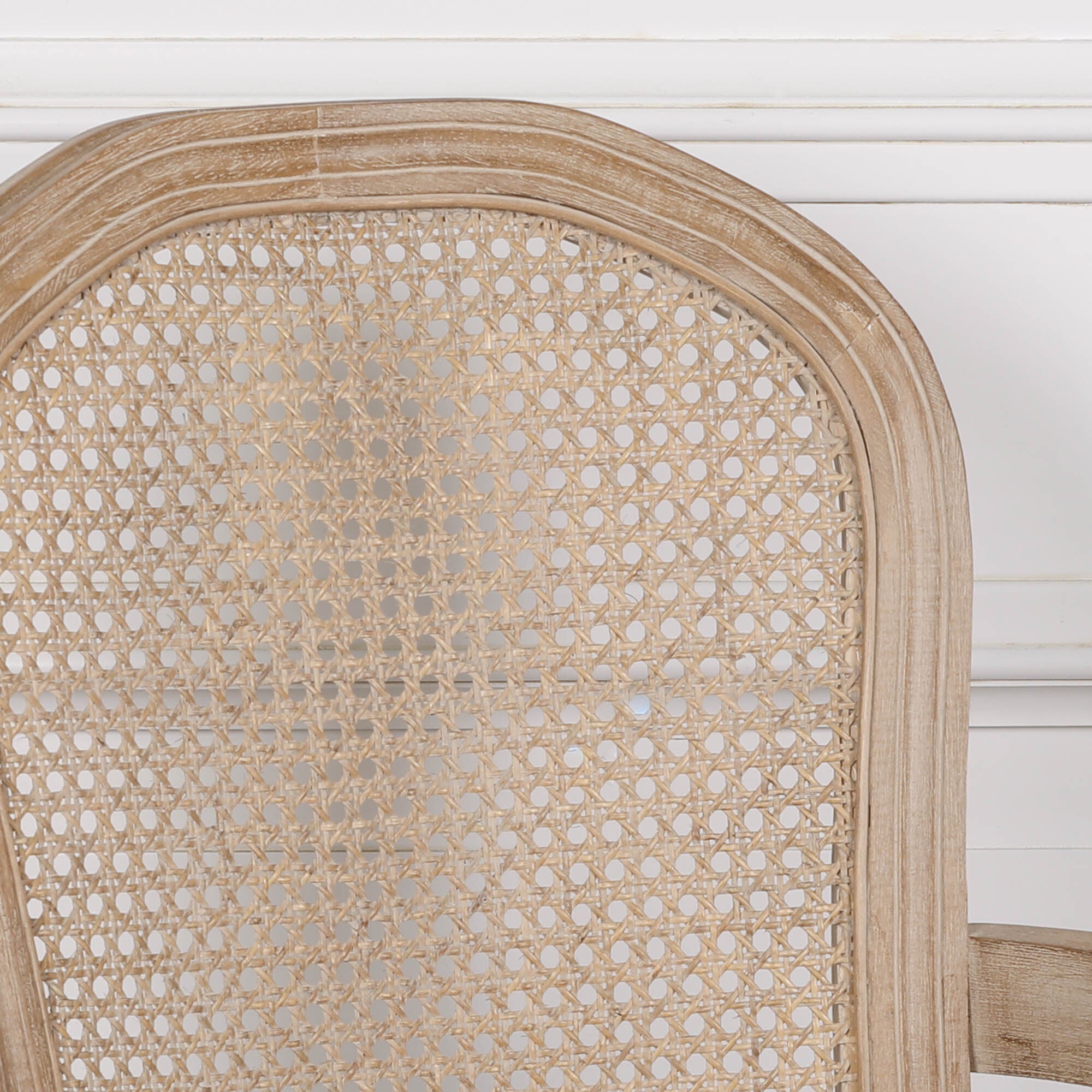 Close-up of Camille birch wood dining armchair showing woven cane back and distressed finish on a white background