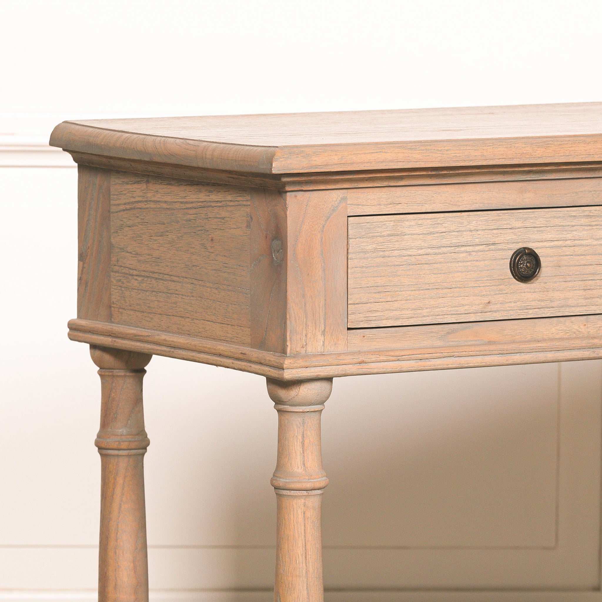 Close-up of the Camille Breakfront white cedar wood console table showing the handcrafted drawer, rustic wood grain, decorative round metal knob and traditional joinery details.