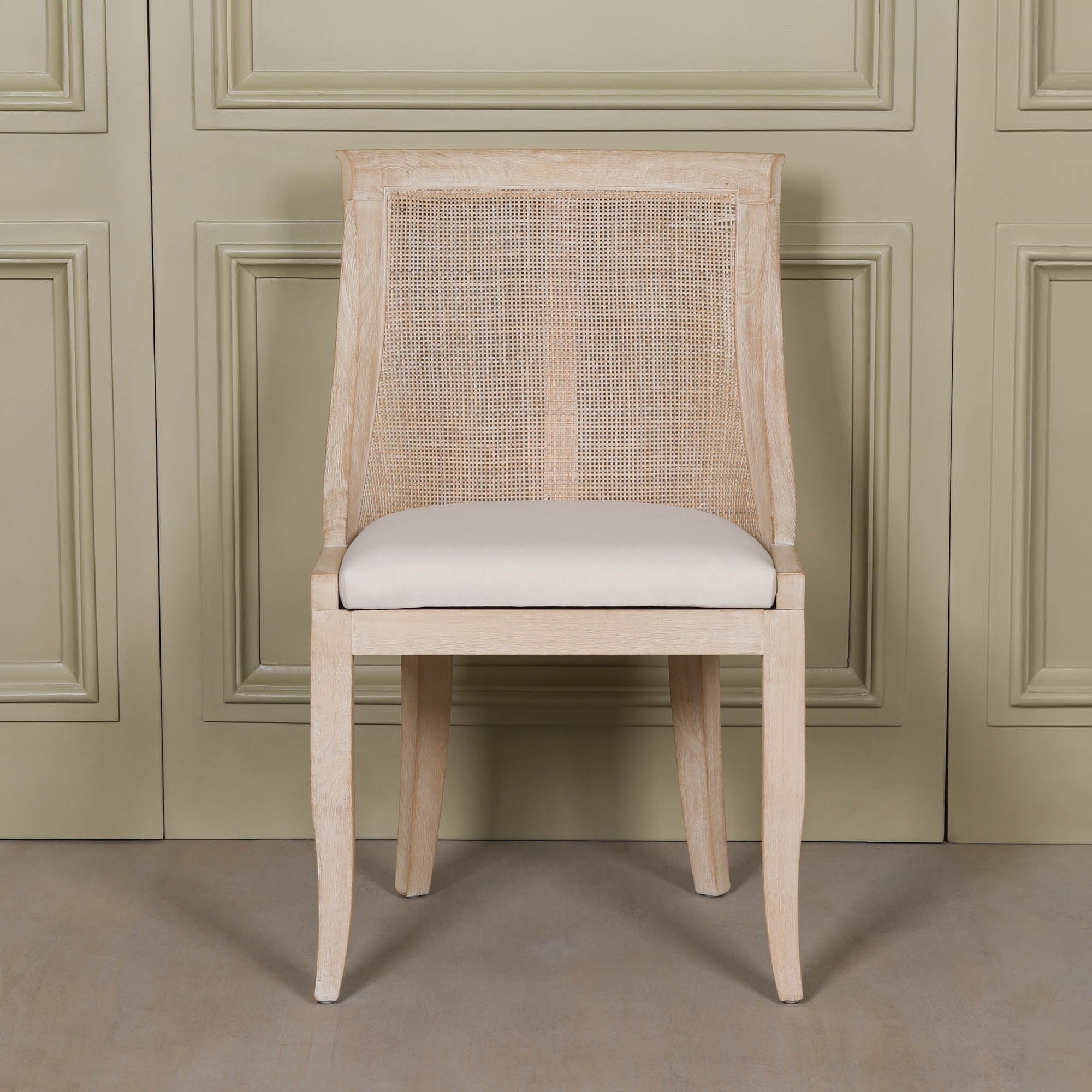 Front view of the Camille Cane Back Dining Chair with a woven cane backrest, beige linen upholstered seat and washed birch wood frame, combining classic French design with relaxed coastal and modern farmhouse styling.