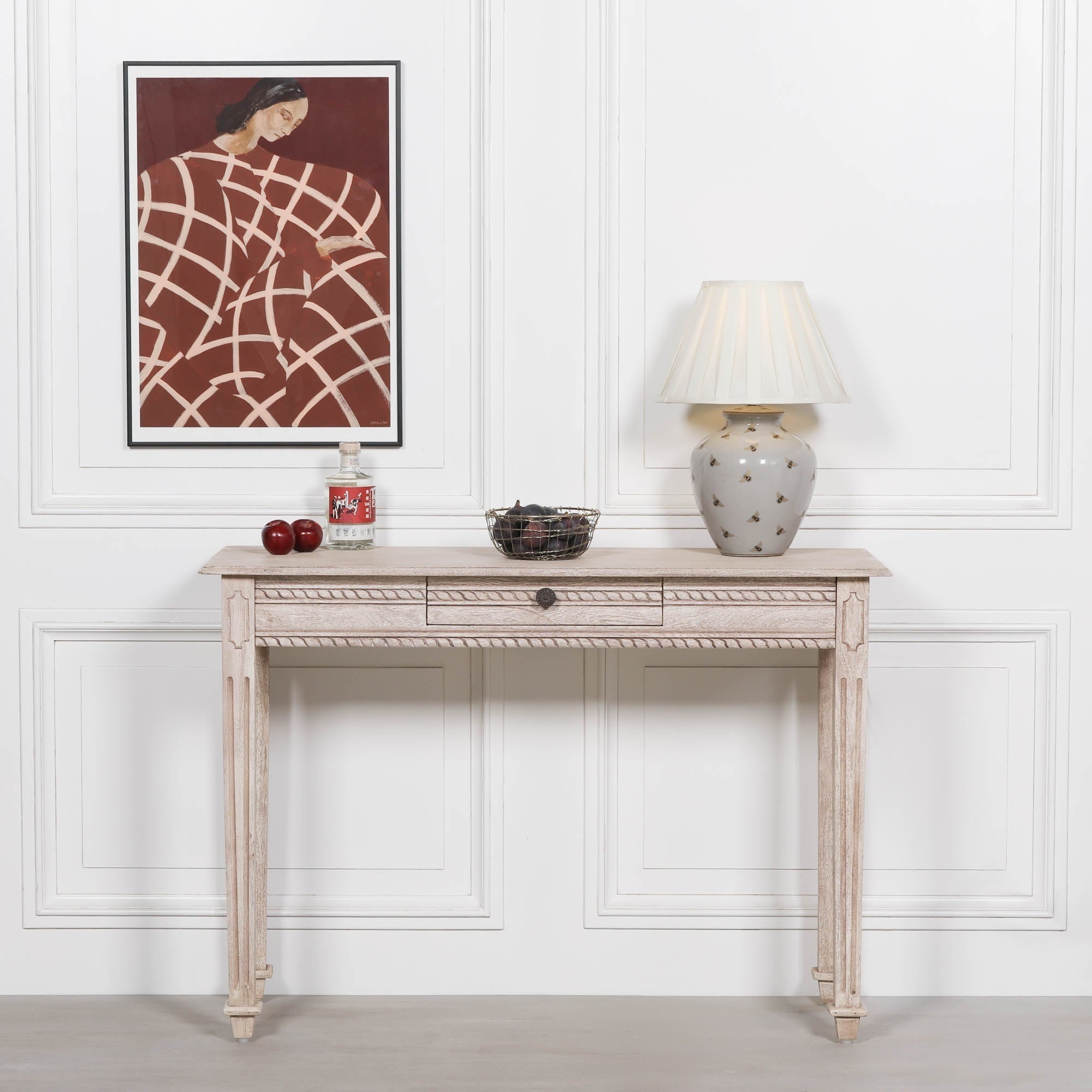 Camille carved acacia wood dressing table with drawer, styled with lamp and artwork against a white panelled wall