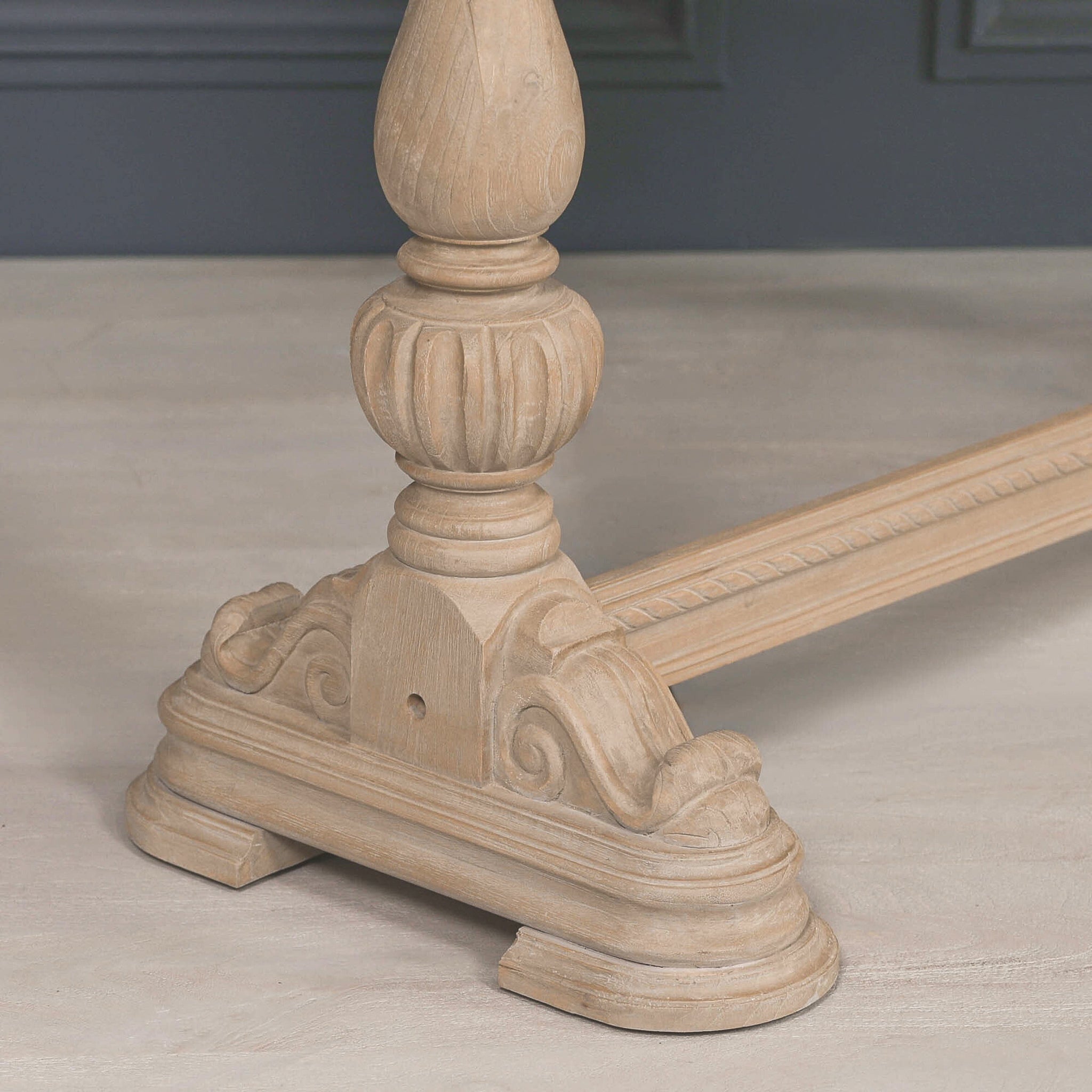 Close-up of the carved pedestal leg and decorative scroll foot on the Camille Carved White Cedar Wood Console Table with Drawer, showcasing the handcrafted detailing, rustic wood grain and traditional French-inspired design.