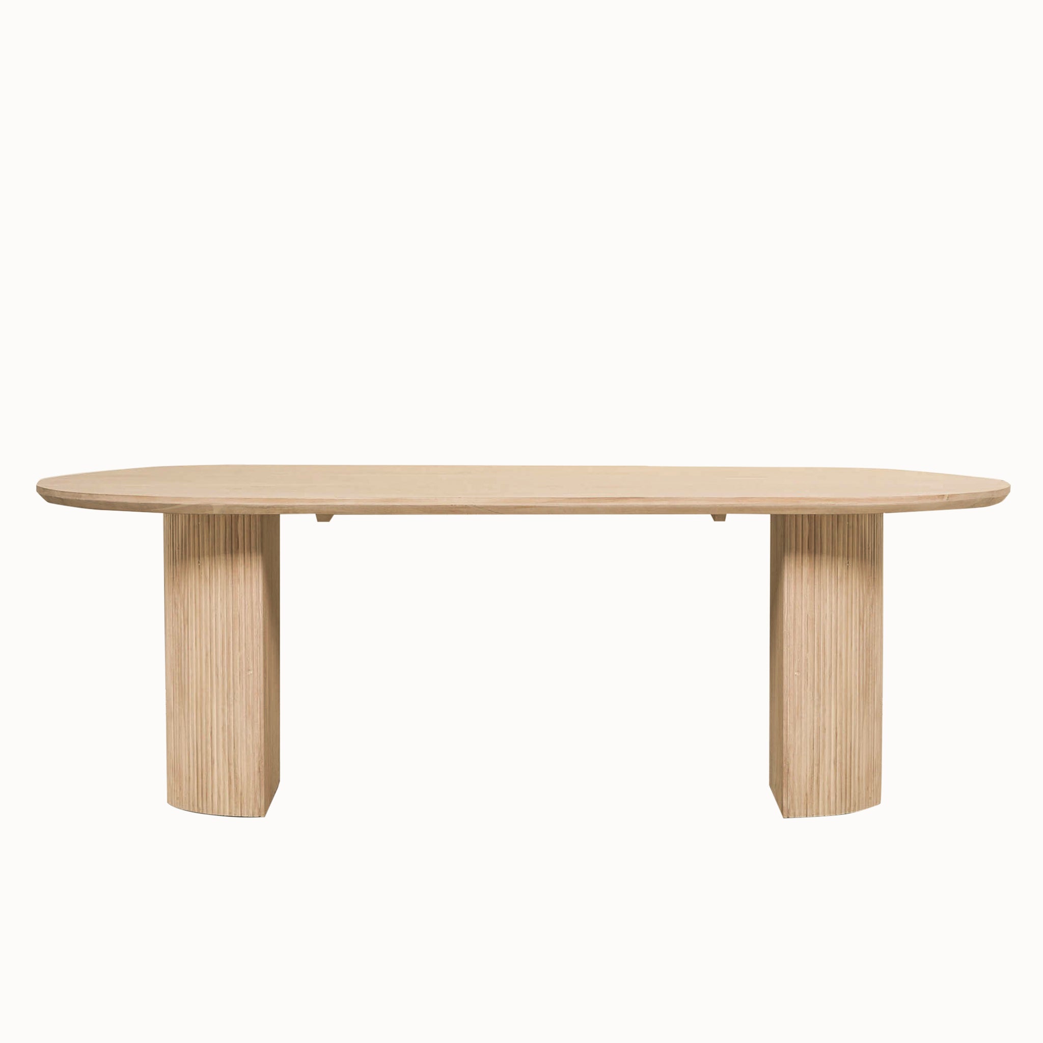 Camille Fluted Acacia Wood Oval 6 Seater Dining Table with a bleached washed wood finish on a white background, featuring an oval acacia wood tabletop with twin fluted pedestal bases for contemporary dining spaces.