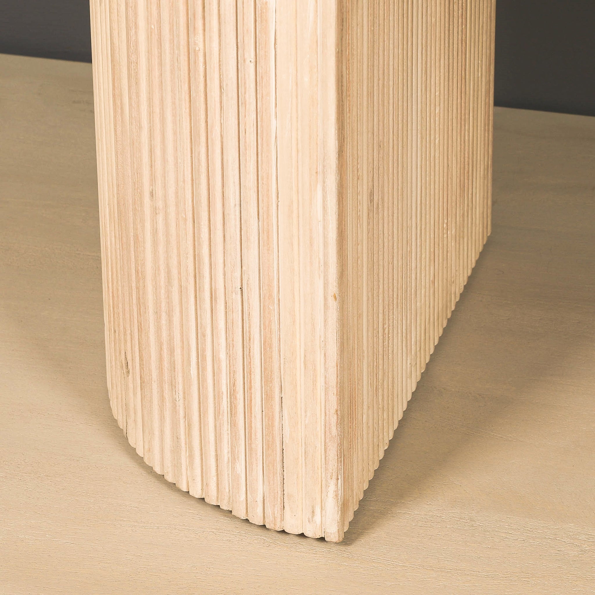Detailed close-up of the fluted pedestal leg on the Camille Fluted Acacia Wood Oval 6 Seater Dining Table, highlighting the ribbed acacia wood detailing, rounded corners and bleached washed wood finish.