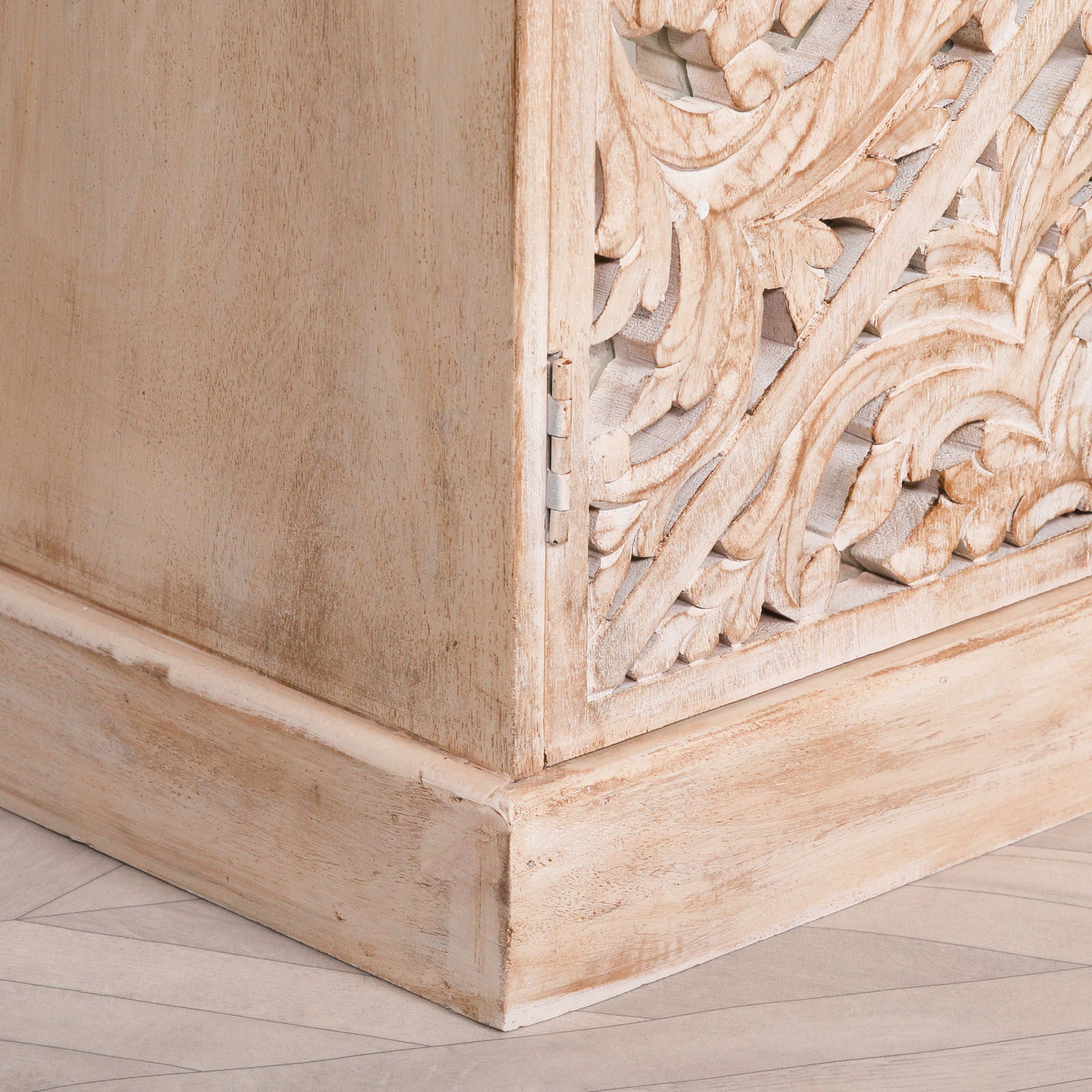 Lower corner detail of the Camille Four Door Carved Mirrored Sideboard showcasing the handcrafted bleached mango wood base, carved mirrored panel and traditional artisan cabinet construction.