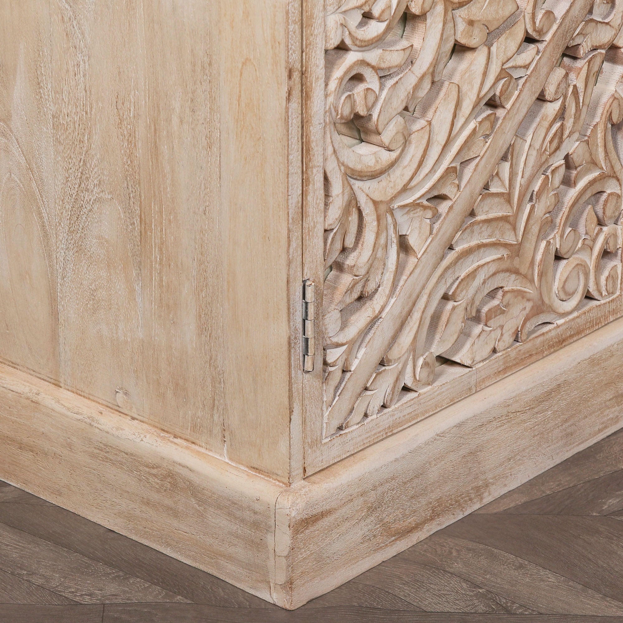 Corner detail of the Camille Four Door Carved Mirrored Sideboard displaying the handcrafted bleached mango wood frame, decorative carved mirrored door panel and artisan furniture construction.