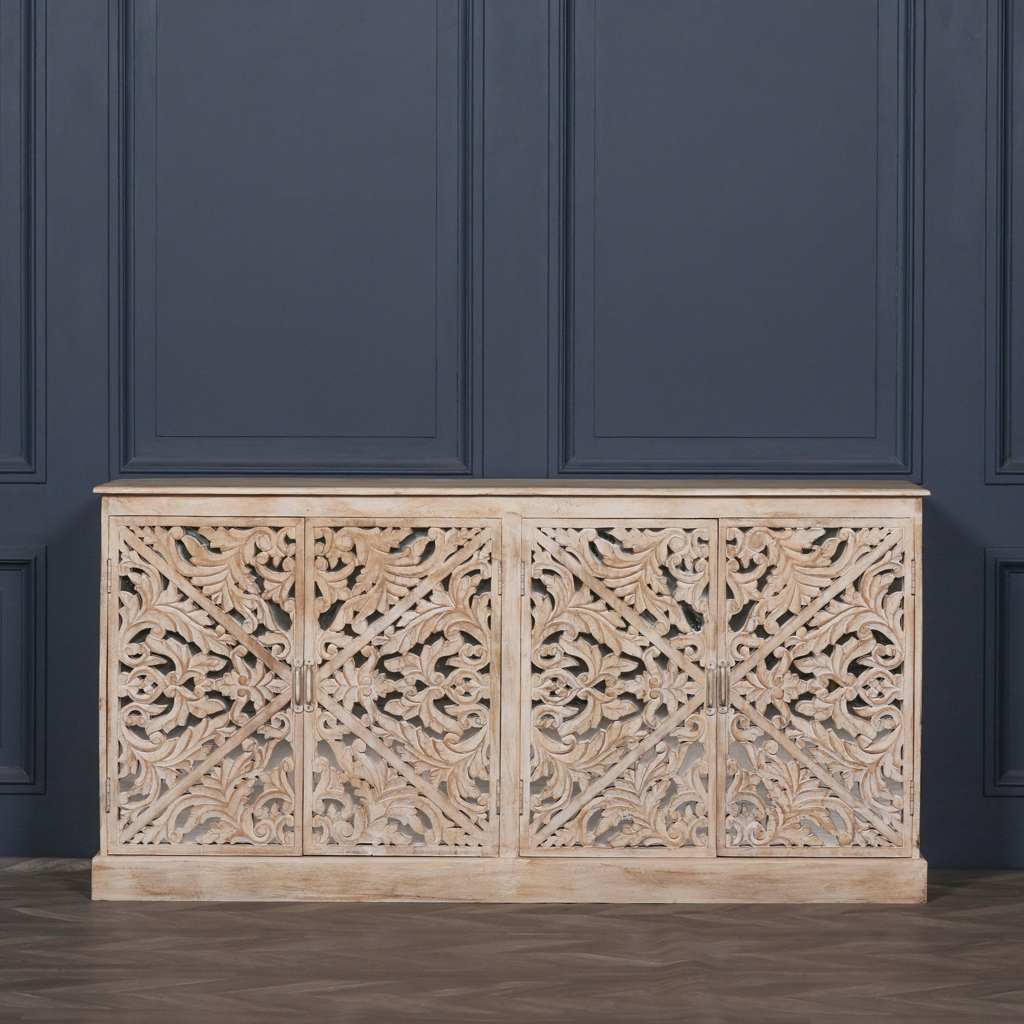 Front view of the Camille Four Door Carved Mirrored Sideboard in bleached mango wood featuring intricate hand carved mirrored doors, generous concealed storage and timeless artisan craftsmanship.