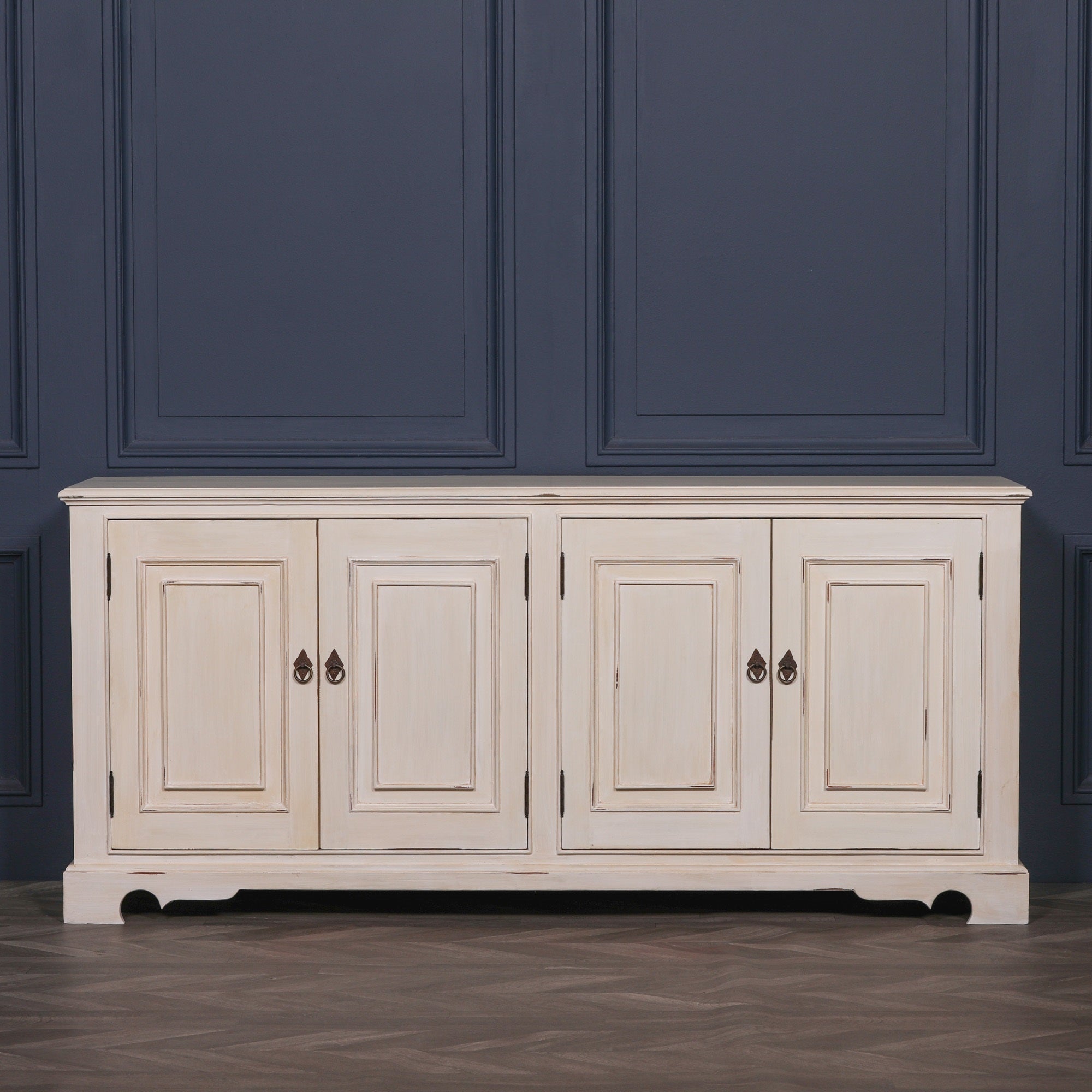 Front view of the Camille Four Door Classical Sideboard in an aged white mahogany finish with four panelled cupboard doors, generous concealed storage and elegant French country inspired design.