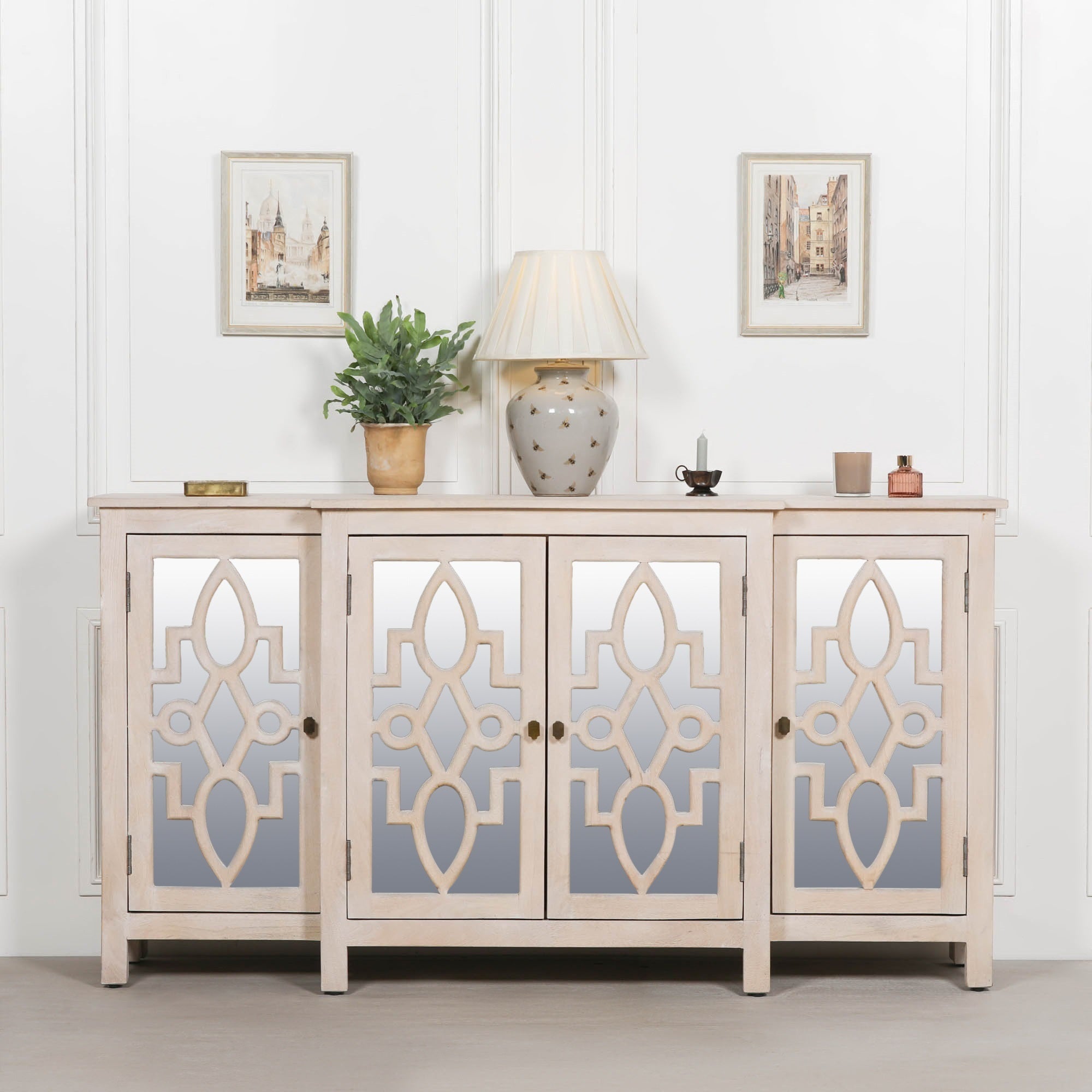 Camille Four Door Mirrored Sideboard in bleached mango wood styled in a luxury living room with decorative accessories, mirrored cabinet doors and spacious concealed storage for elegant interiors.