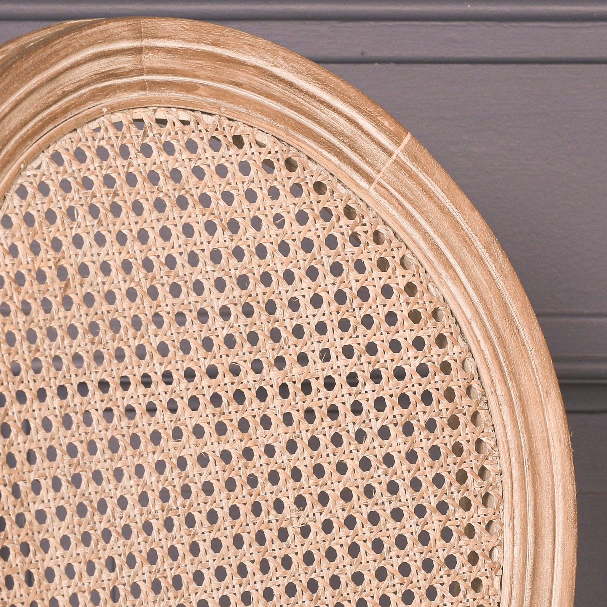 Close-up of the Camille French Louis Linen Upholstered Dining Chair highlighting the woven natural cane backrest, oval carved wooden frame and handcrafted French Louis design.