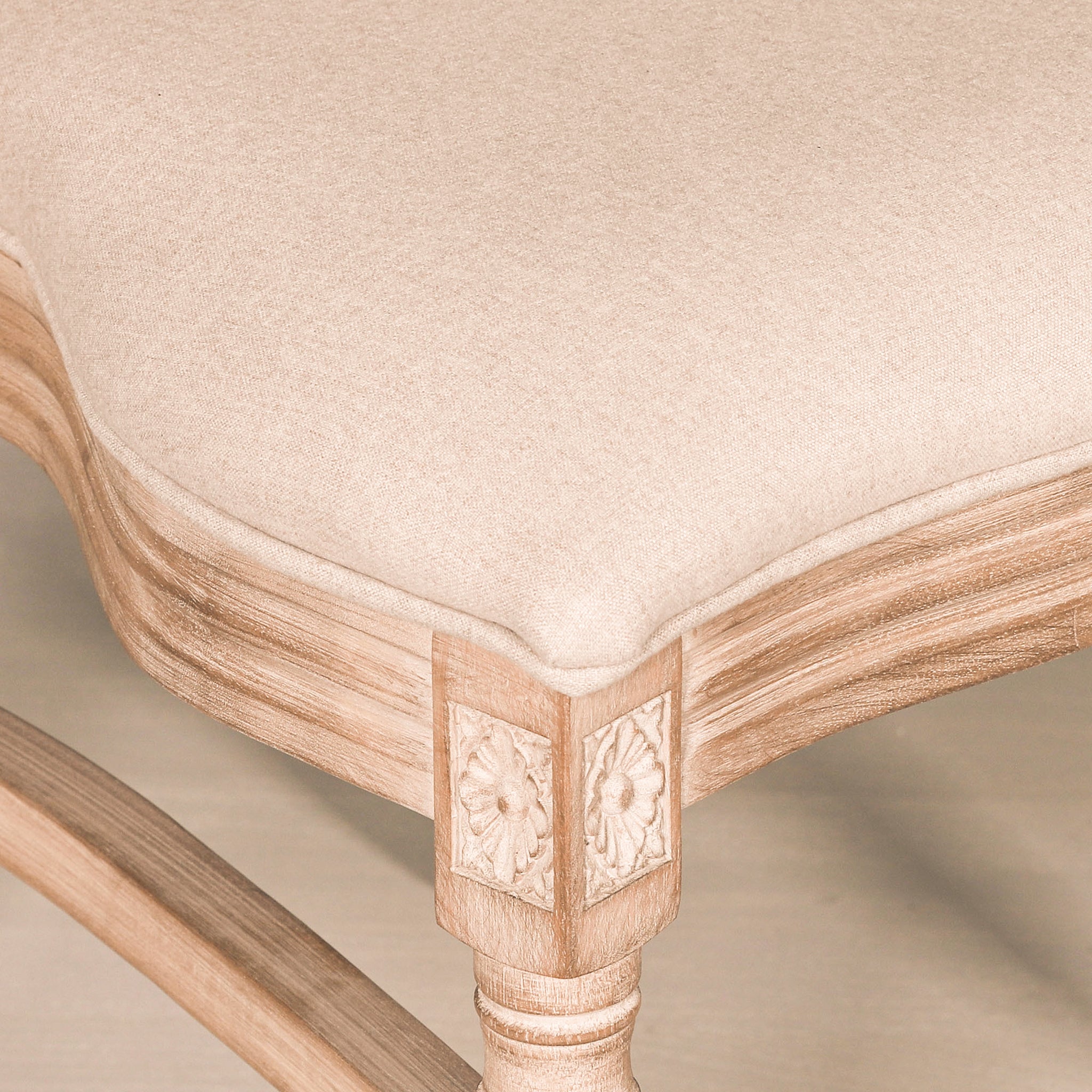 Close-up of the Camille French Louis Linen Upholstered Dining Chair featuring the linen upholstered seat, hand-carved floral corner detailing and beautifully shaped solid wooden frame.