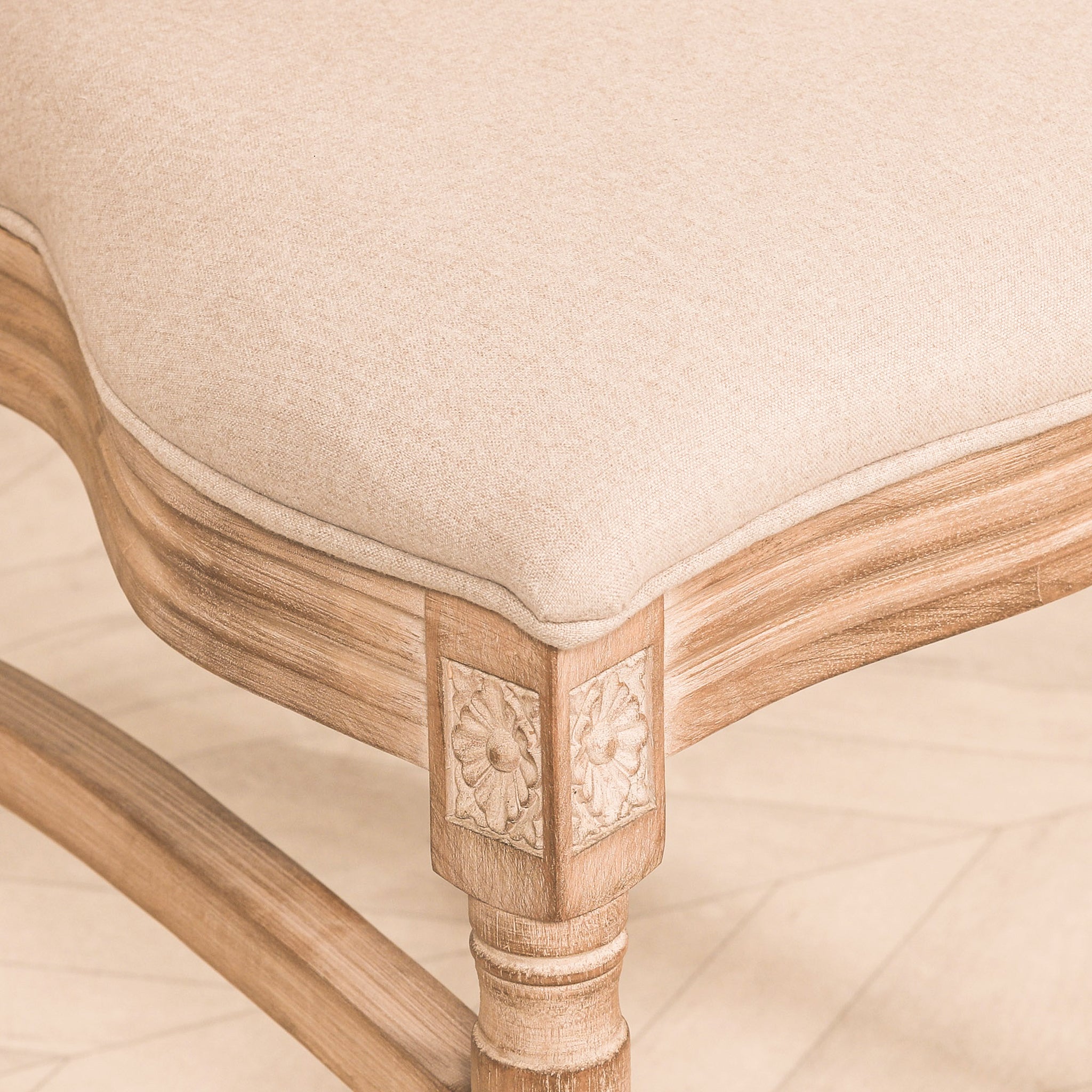 Detailed close-up of the Camille French Louis Linen Upholstered Dining Chair showcasing the carved wooden leg, decorative floral corner carving, curved seat rail and premium linen upholstery.