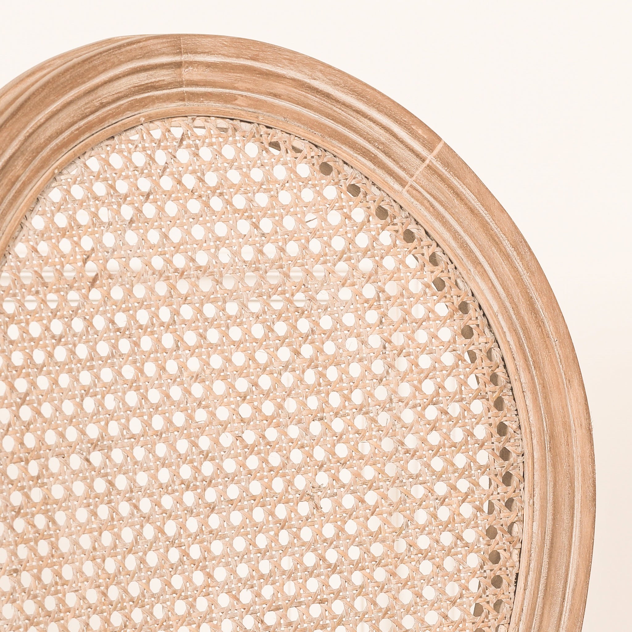 Extreme close-up of the Camille French Louis Linen Upholstered Dining Chair showcasing the finely woven natural rattan cane backrest surrounded by an elegant carved wooden oval frame.