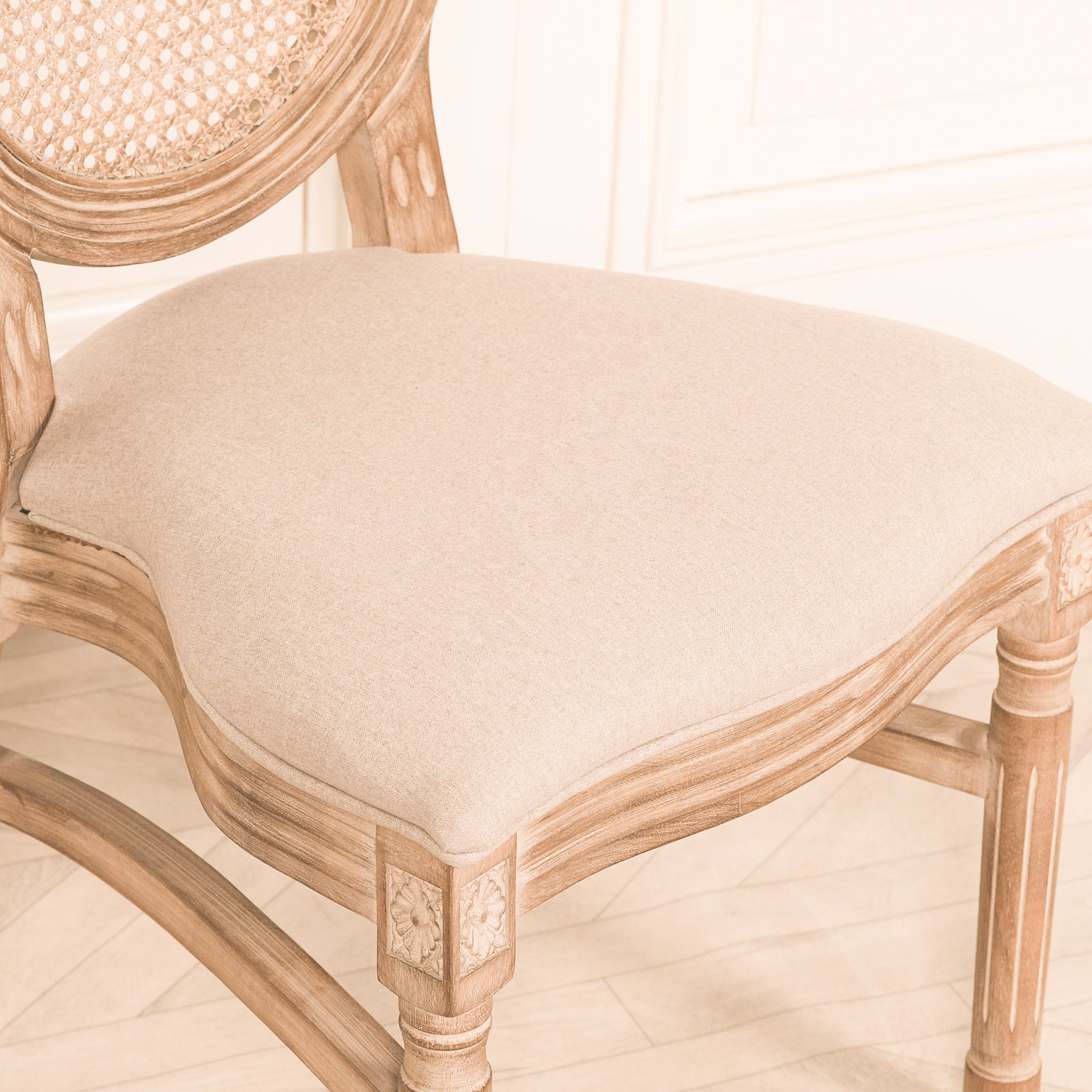 Detailed side view of the Camille French Louis Linen Upholstered Dining Chair highlighting the premium linen seat cushion, carved wooden frame, decorative corner carvings and woven cane backrest.